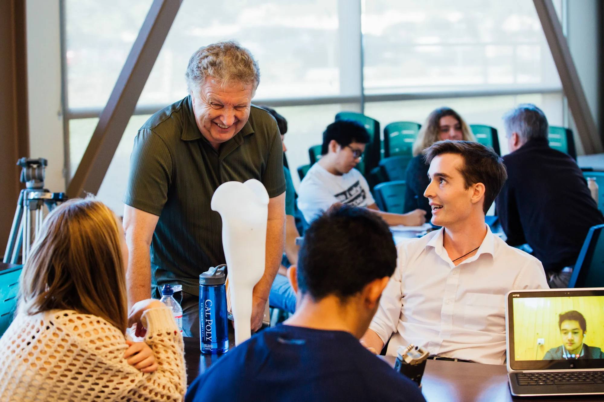 Members of the Cal Poly student team talking with Douglas during a design meeting