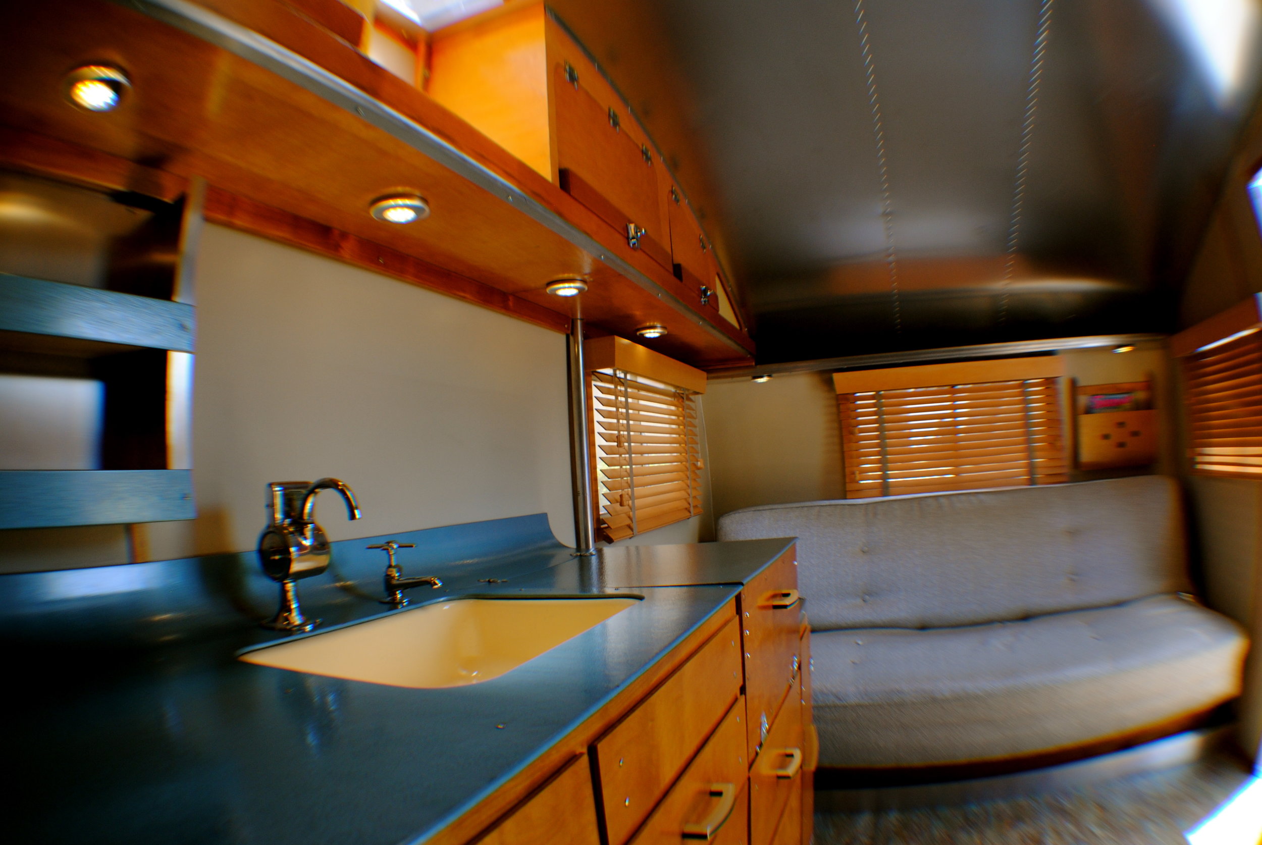 Original countertop, sink, water pump and sofa with new cabinetry, walls, ceiling and lighting.