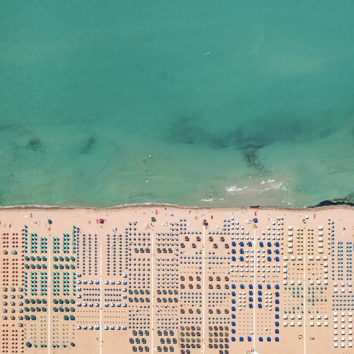 Come colorati circuiti elettrici gli ombrelloni della Versilia nella fotografia aerea di Bernhard Lang