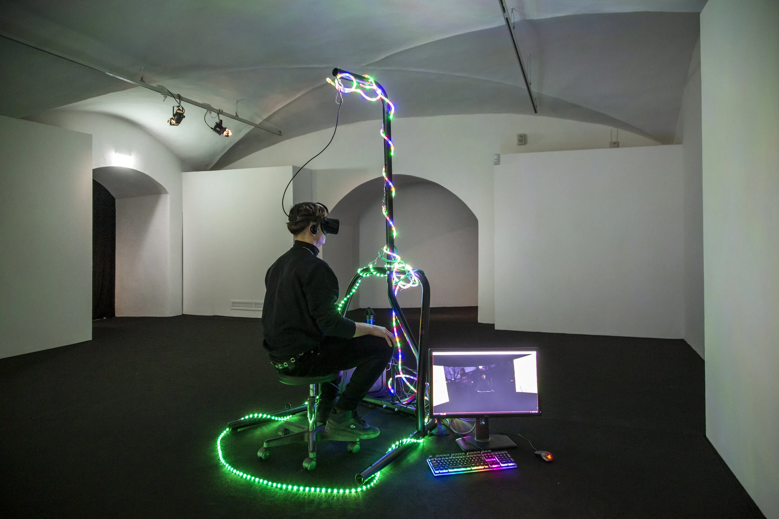 Patrick Alan Banfield (1984, Gran Bretagna; vive e lavora in Germania) Installation view, MEIN BLICK (MY VIEW), 2017. Installazione di realtà virtuale: video 10’7’’, sedia da ufficio, Gaming PC, Visore VR, punchball stand. Courtesy l’artista ph. Fed…