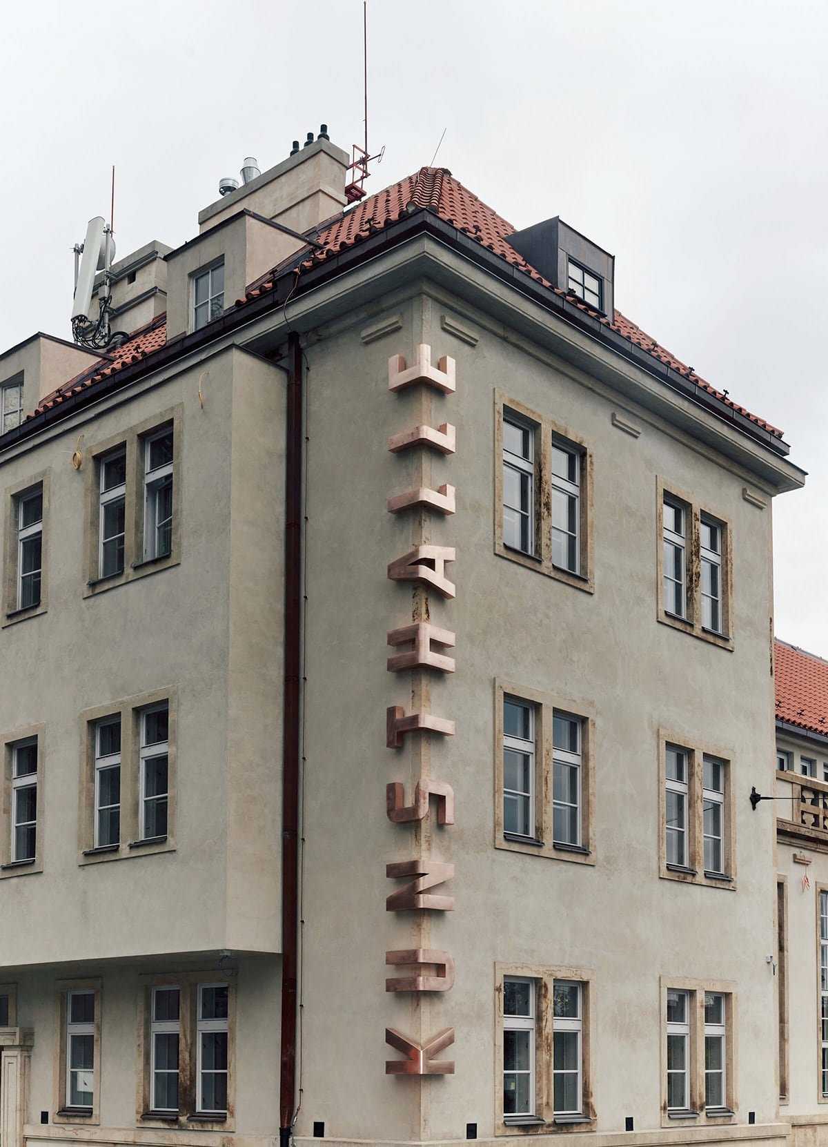 Il logo di Kunsthalle Praha, che avvolge l'angolo del museo con spesse lettere in bronzo