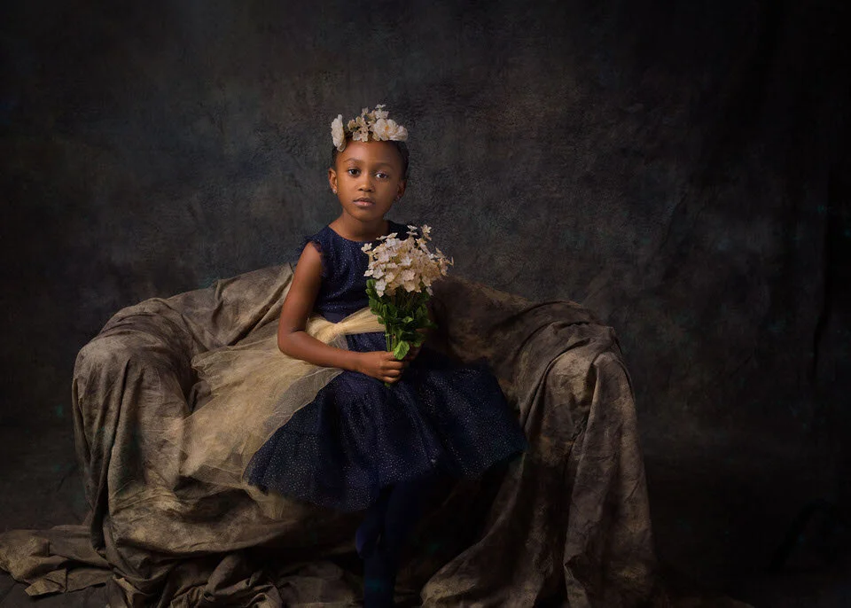 BIPOC young girl in blue gown seated bouquet
