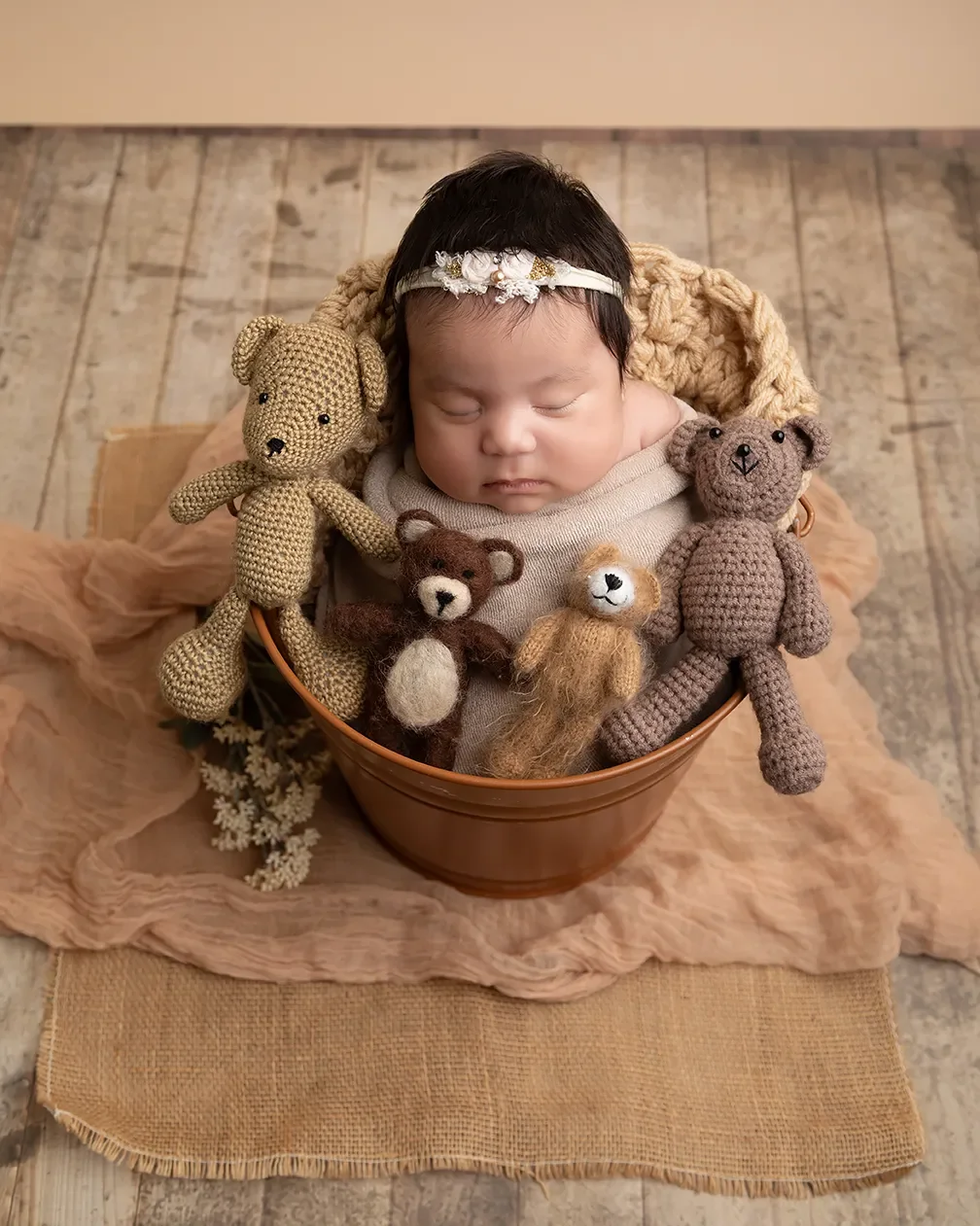  Newborn baby girl photographed in a Glendale California studio in a bucket surrounded by teddy bears. 