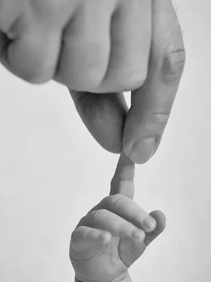  Close up image of Dad and newborn son’s hands togeter. 