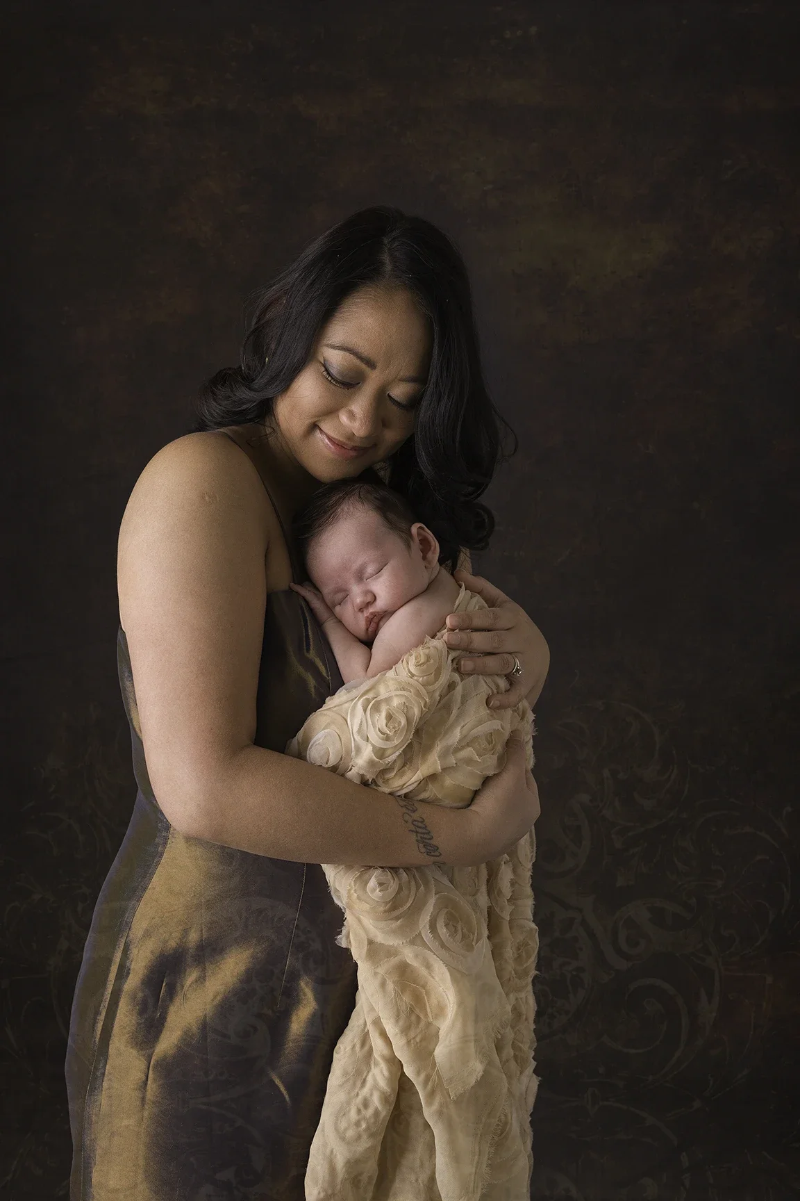 Mother holding her sleeping newborn close during a Mommy & Me portrait session in Los Angeles.