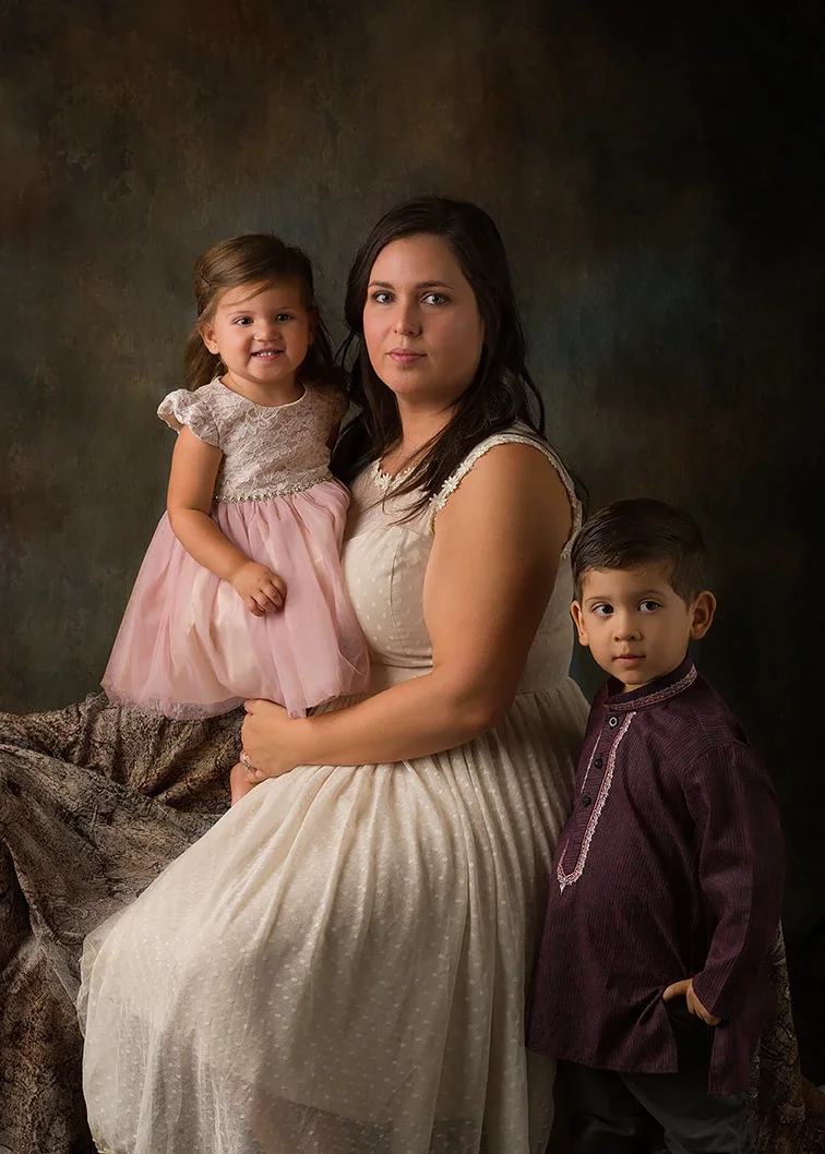Mom with two young children wearing coordinated ivory, blush pink and burgundy outfits for a Mommy and Me photography session in Los Angeles.