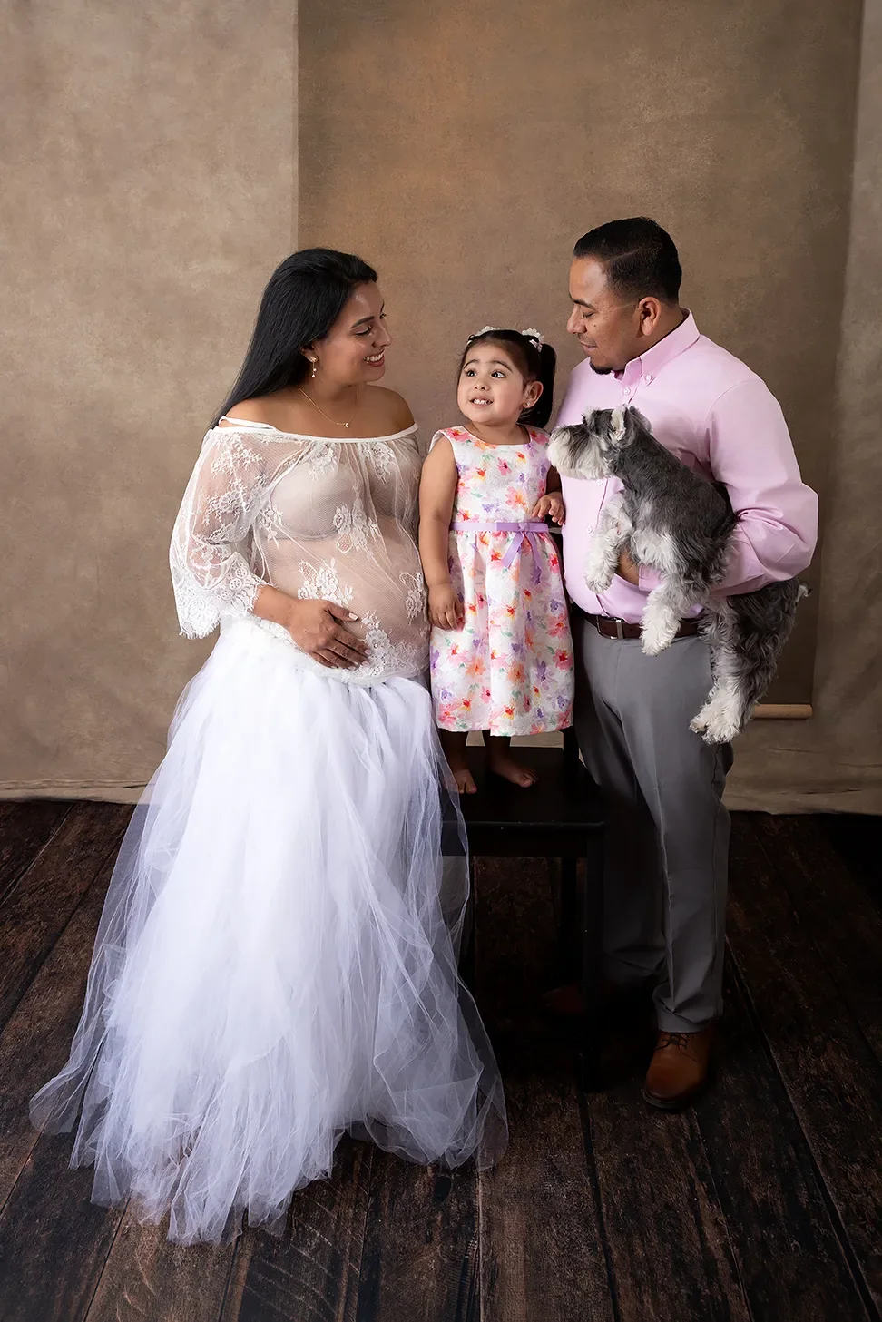 Pregnant mother with husband, toddler daughter, and family dog during a studio maternity photography session in Los Angeles.