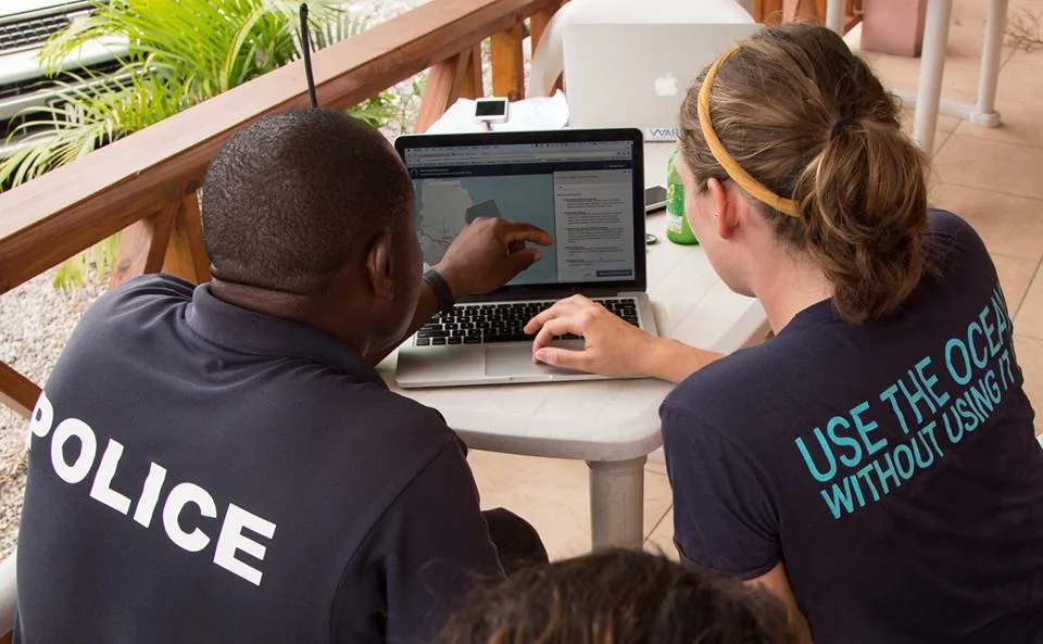 Grace Goldberg interviewing George Ryan, Marine Division Police, in Little Bay. Photo credit Will McClintock.