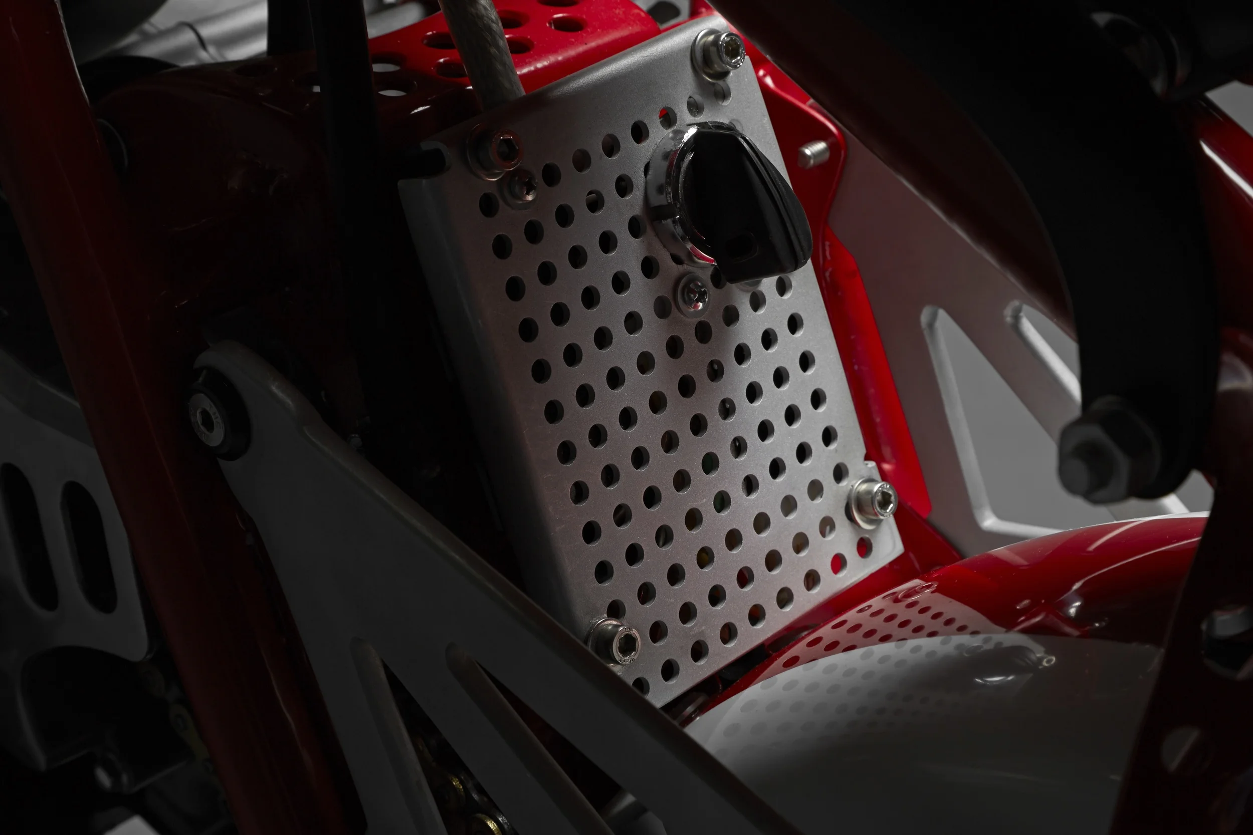 Underneath the seat a panel conceals the CDI and voltage regulator, and houses the ignition switch. The panel was taken from the innards of a medical ultrasound machine.