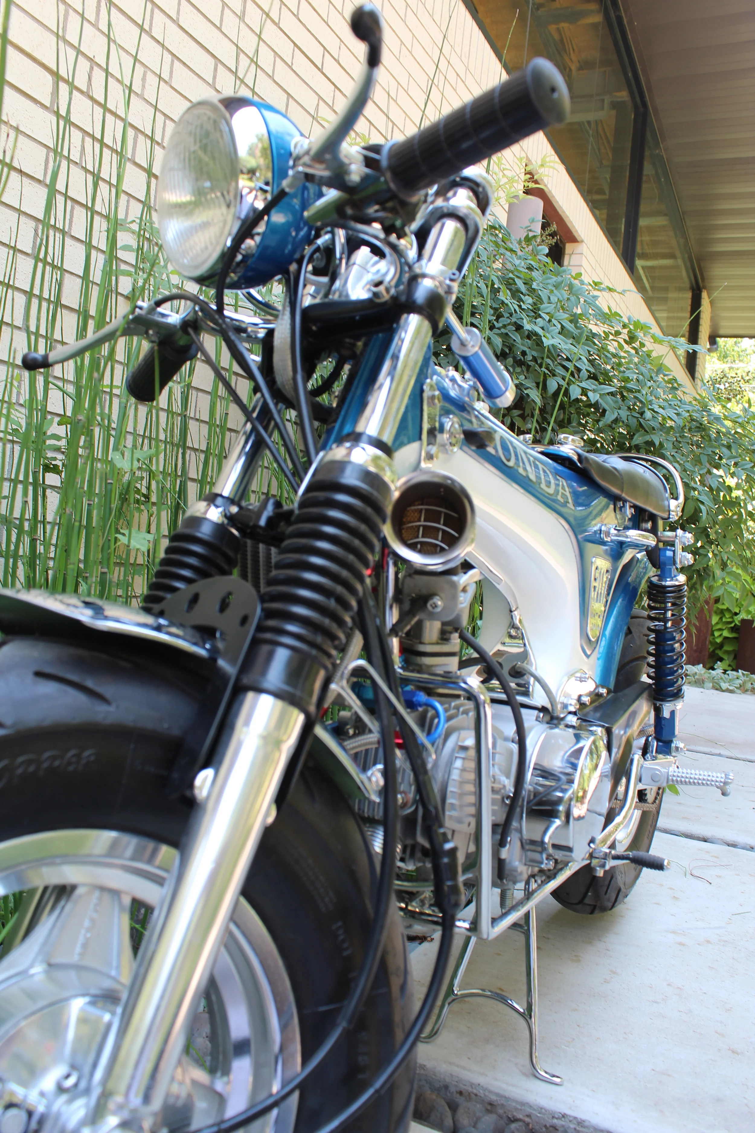 The stock forks were rebuilt and a custom fork brace added. The handlebars are on a modified inverted triple clamp, that allows them to be slid along the fork tubes.