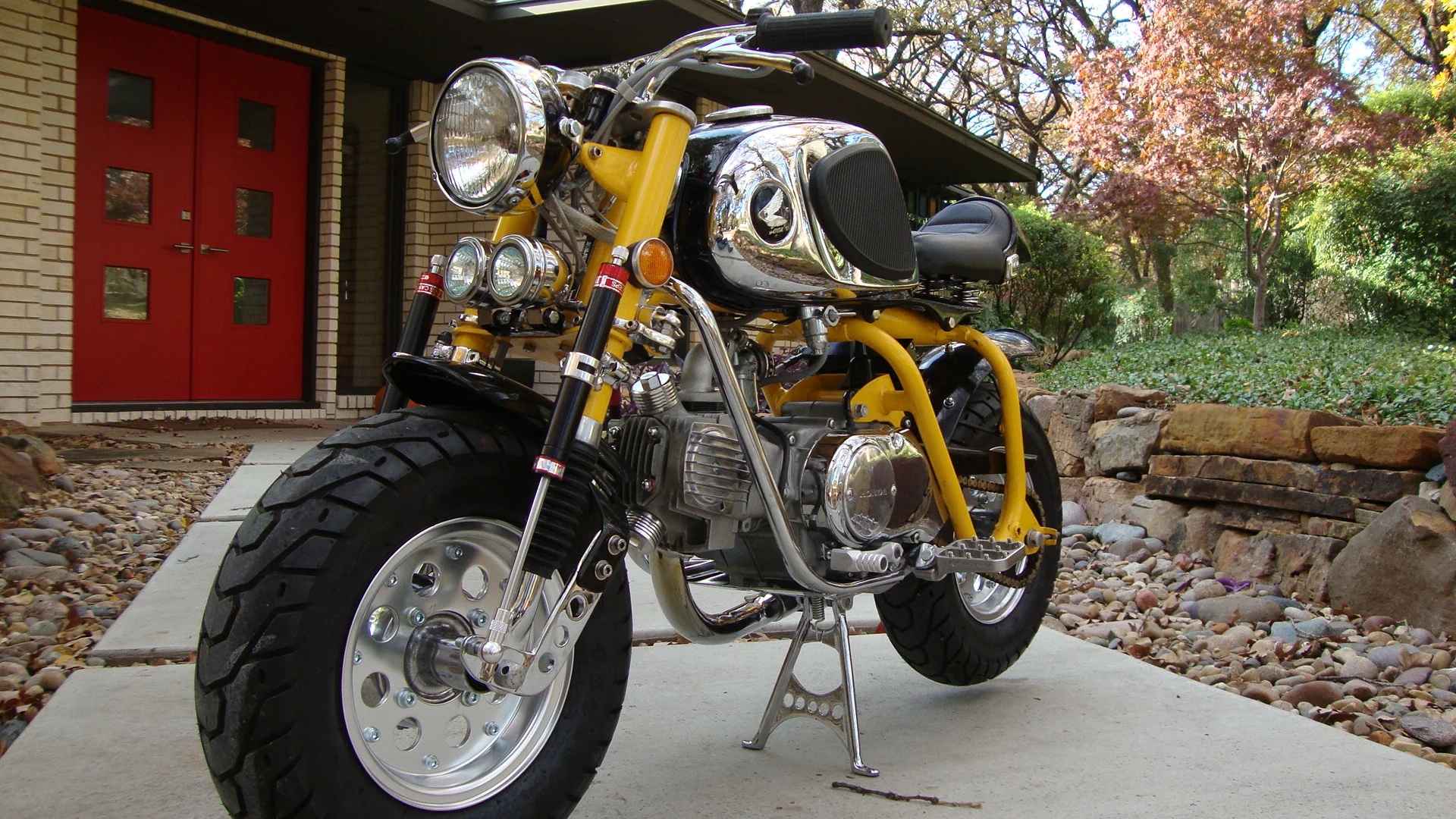  Though there are graphics on the sides of the tank, the stock covers and knee grips look pretty good, so there is usually one on the bike. Custom center stand, handlebars, and fenders. The engine cradle is a modified CT90 piece. Front steering and s