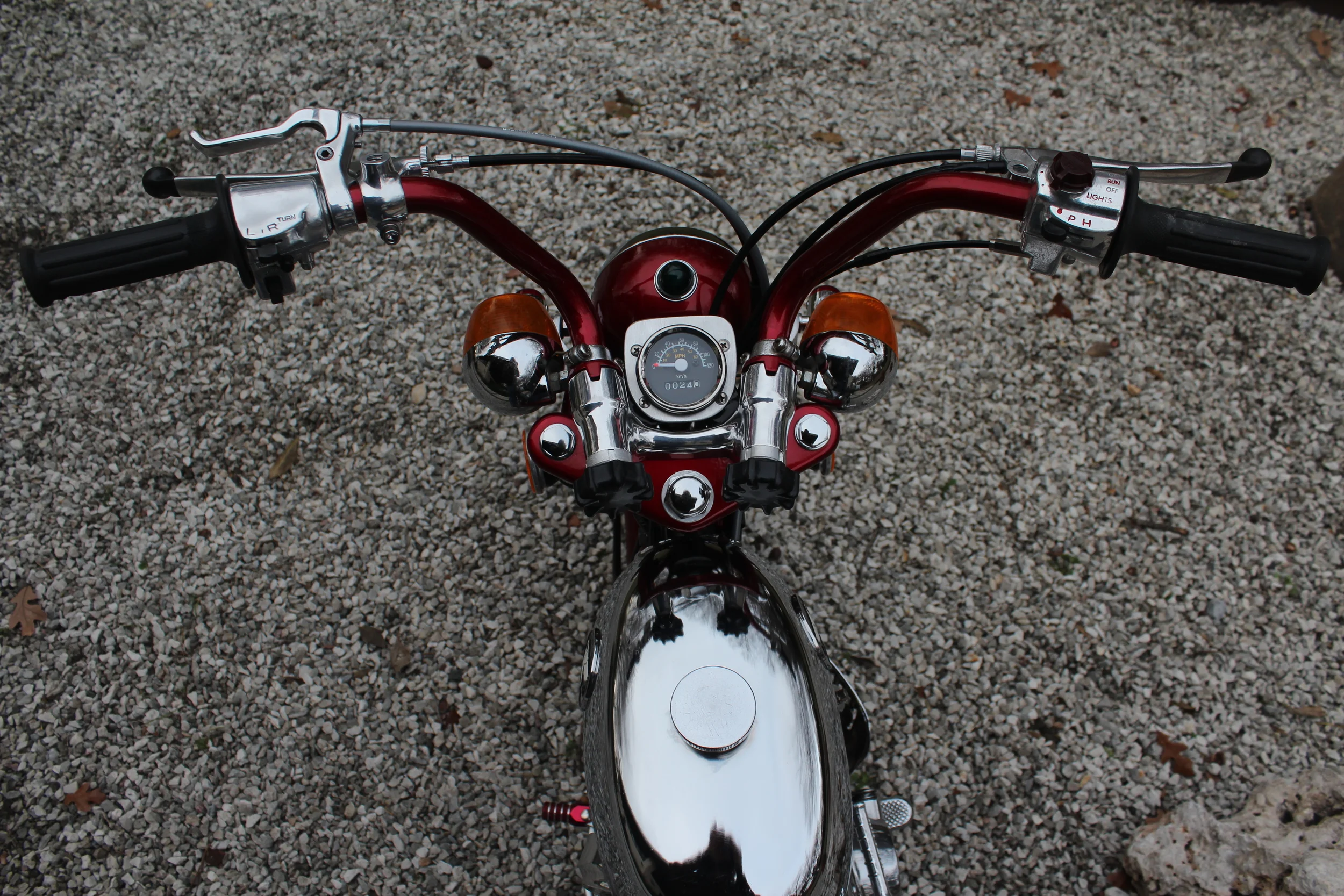   Crome plated Trail-Jet tank with Honda badges. SL70 handlebar controls. CT70 top clamp and handlebar mount. An extra lever on the left handlebar for the rear brake. 
