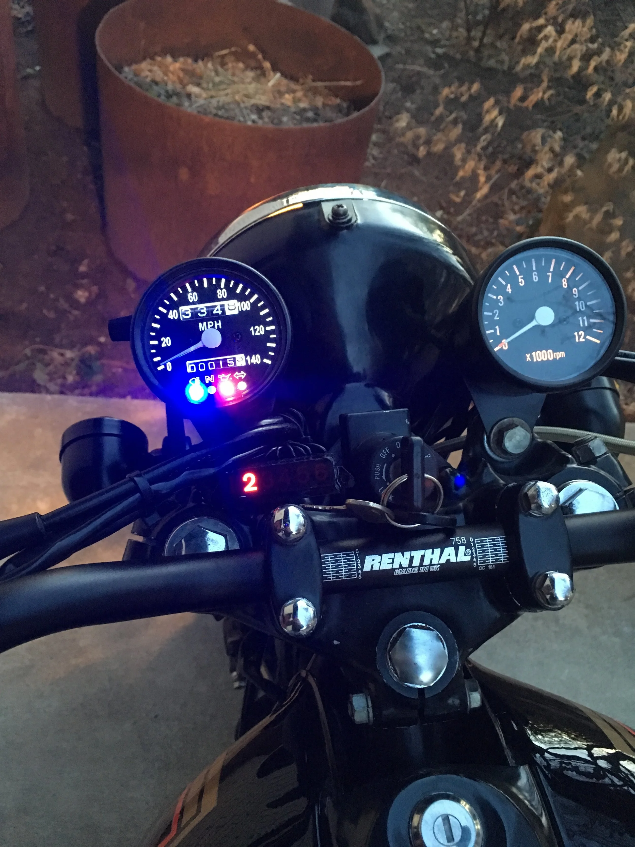  I love Renthal products, mostly their bars and chains. In this pic, the stock gear selector indicator was removed from the huge original speedo housing and made to fit on the lower left side. 