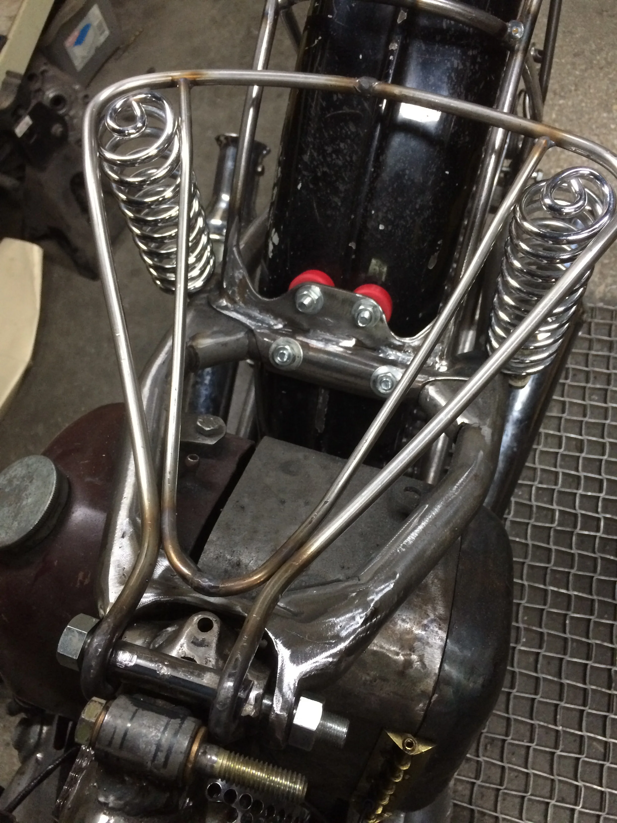  The beginnings of the seat assembly in stainless rod. Because of the asymmetry of the rear frame, the seat was made to fudge the difference and keep the lines looking right. A Lycett-style spring assembly and some more bracing went into finishing th