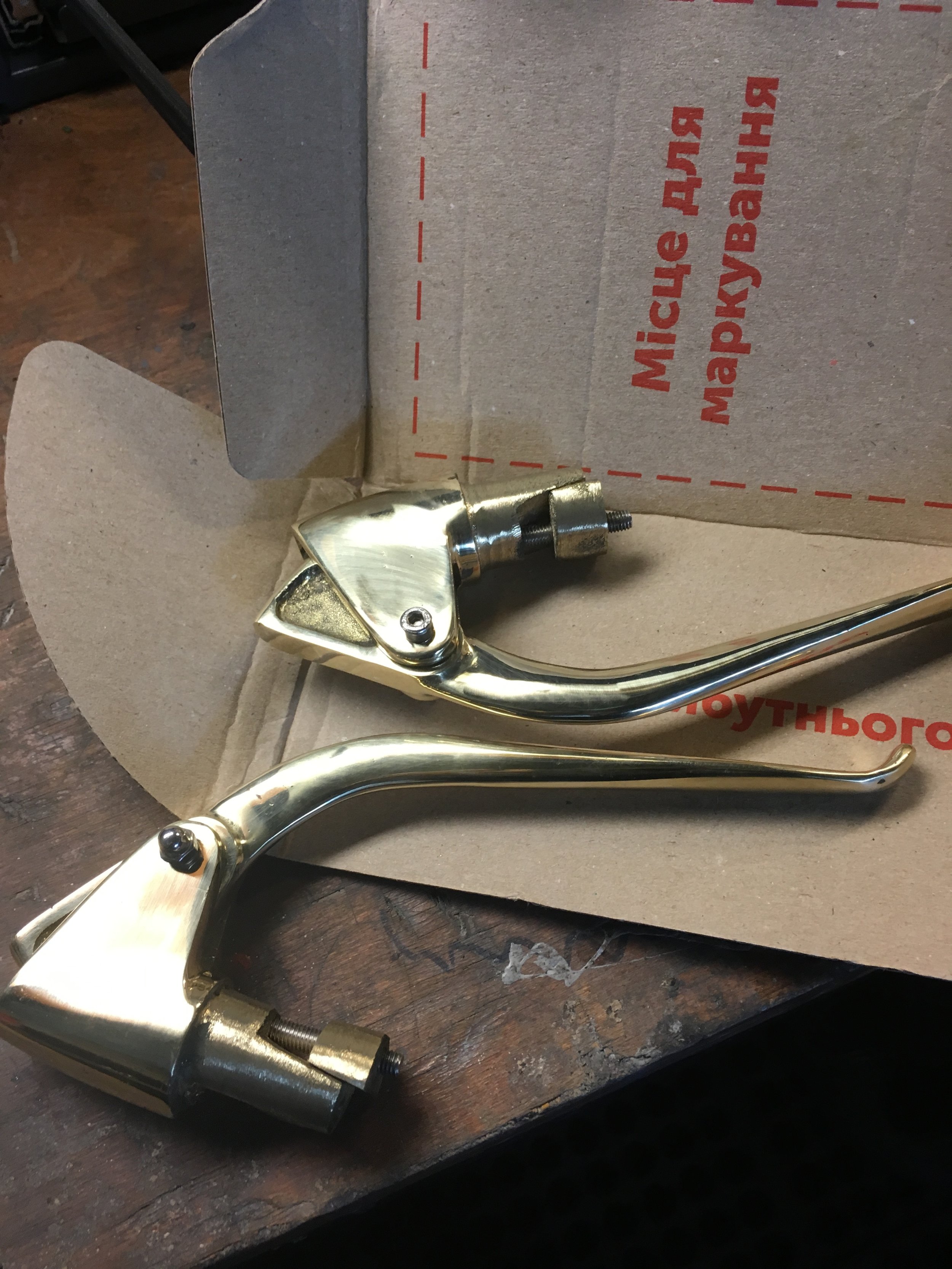 These are the brass reverse levers going on the bike. They are made by hand in Ukraine and are a BMW knock-off. The holes for the screws had to be enlarged to allow the cams to slide enough to tighten them up and the cable perches needed filing out,…