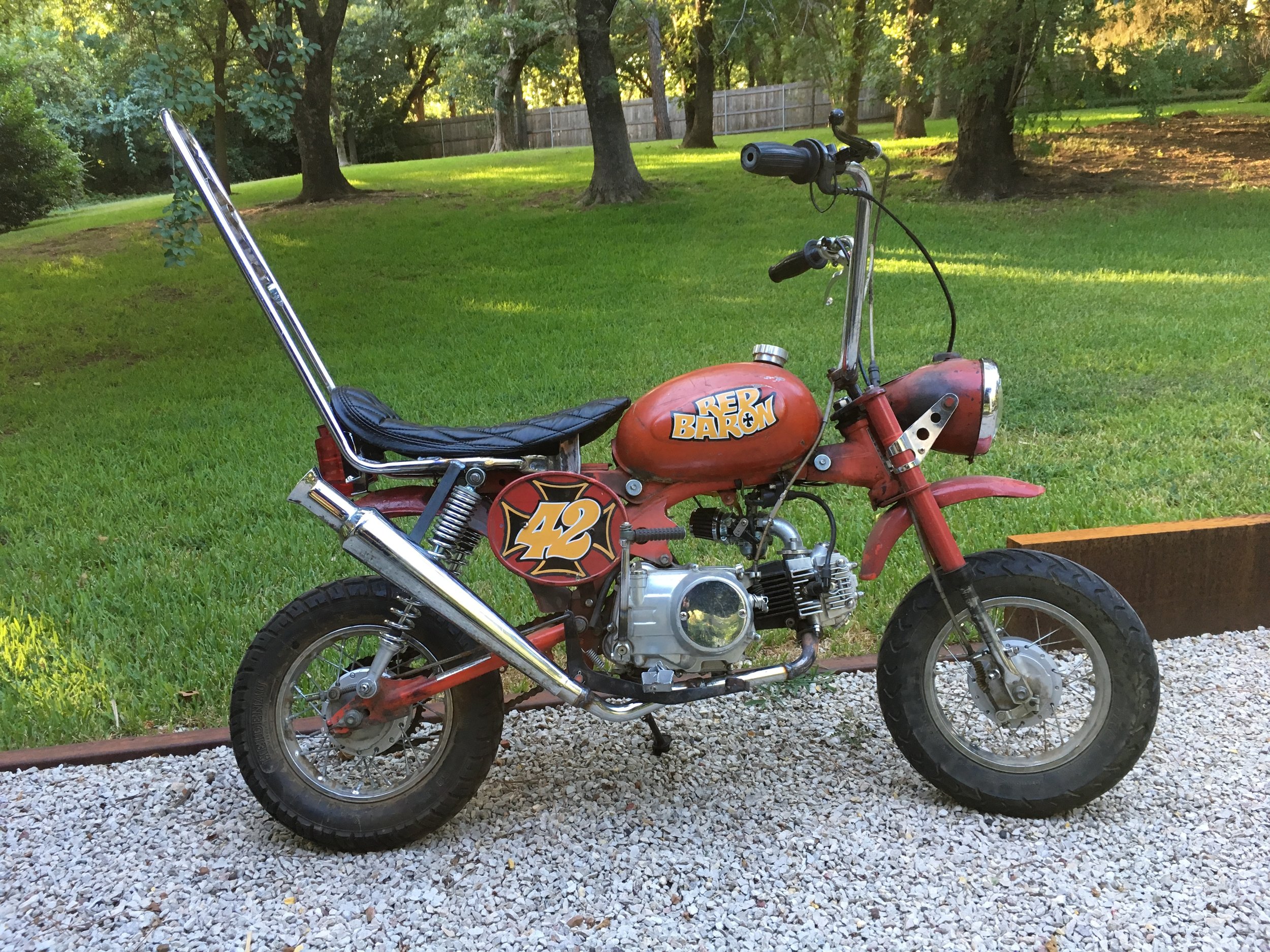  Modified in several sessions spread over a couple years, the Red Baron might be considered complete…but you never know. The most recent round was to add the banana seat, sissy bar and low pipe. 