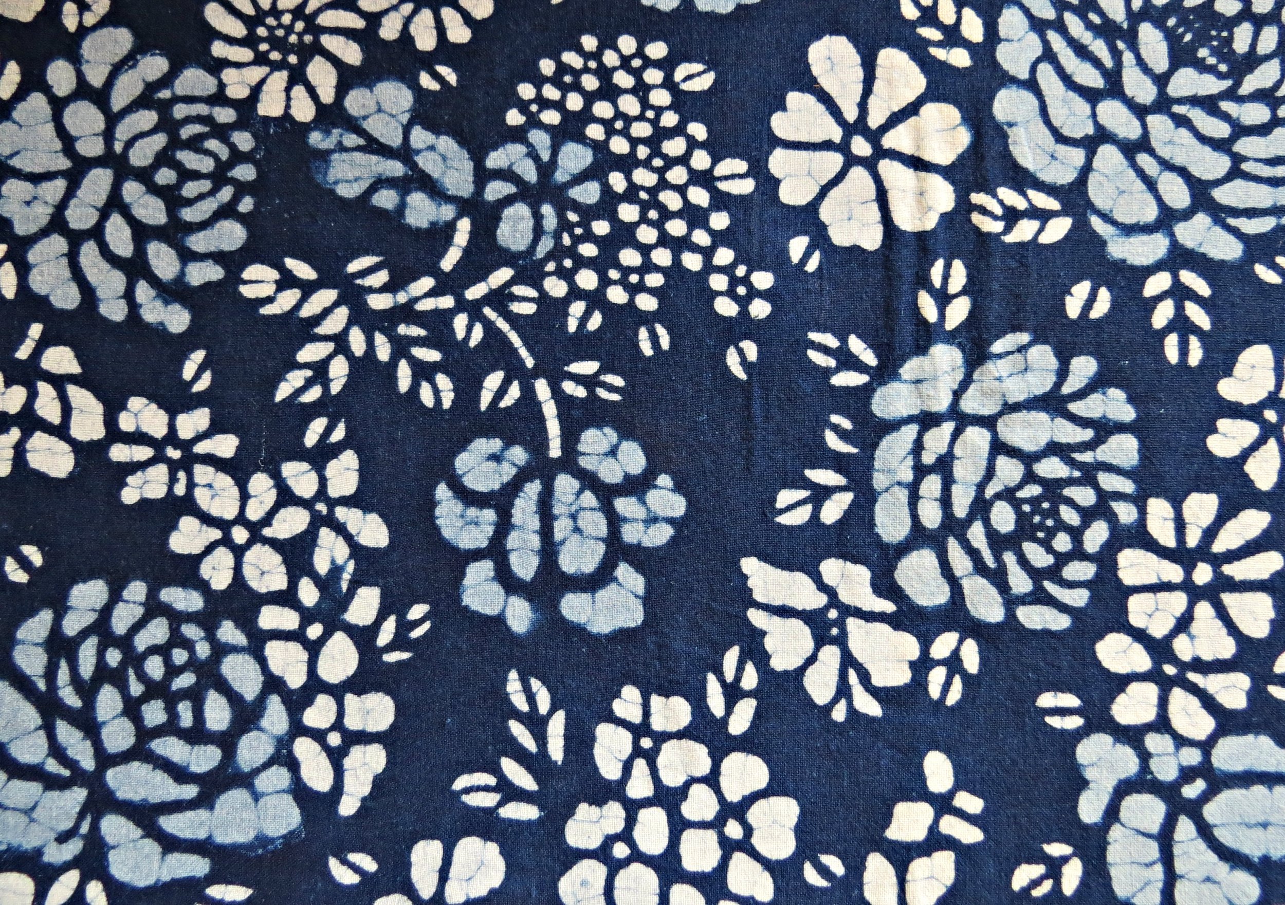 I have not actually been anywhere to see the Batik process, but I am almost certain that this piece is batik. You can tell by the small lines in the design, which is where the wax cracked and allowed some dye to penetrate the cloth. This is also a good example of the two tones of blue sometimes seen.