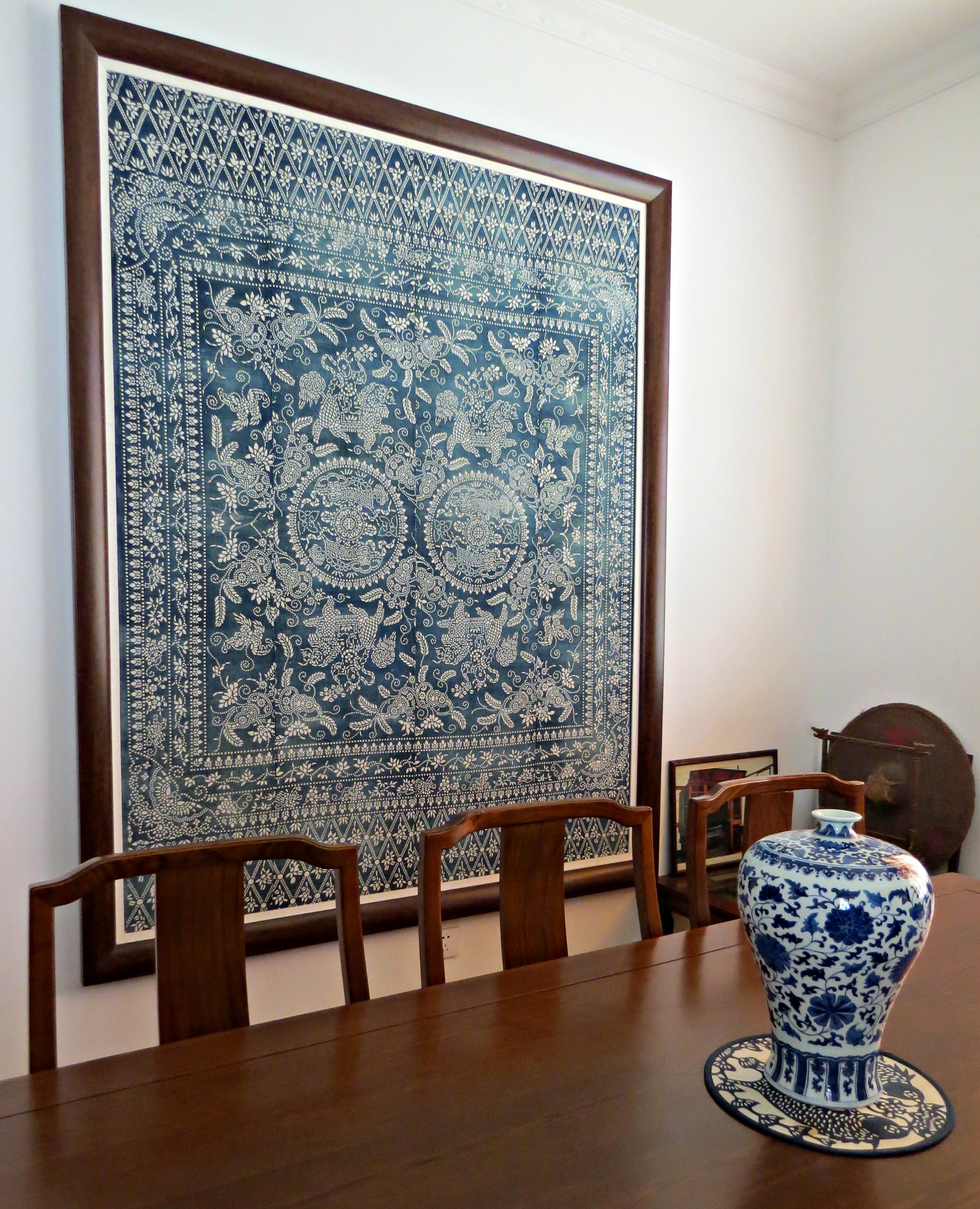 A framed piece of antique cloth, displayed with some blue and white pottery at the Chinese Blue Nankeen Exhibiton Hall in Shanghai