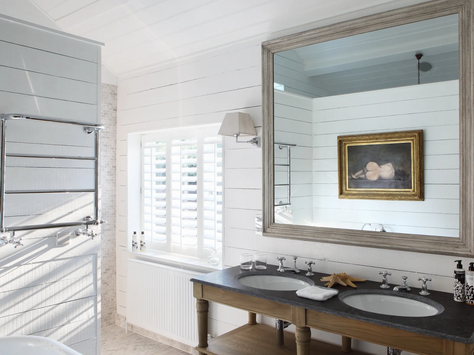 This is from one of our turnkey projects- The Barn on the Green. We really love the simple painted wood panelling on the walls paired with a soft painting. Click here to see the entire project .