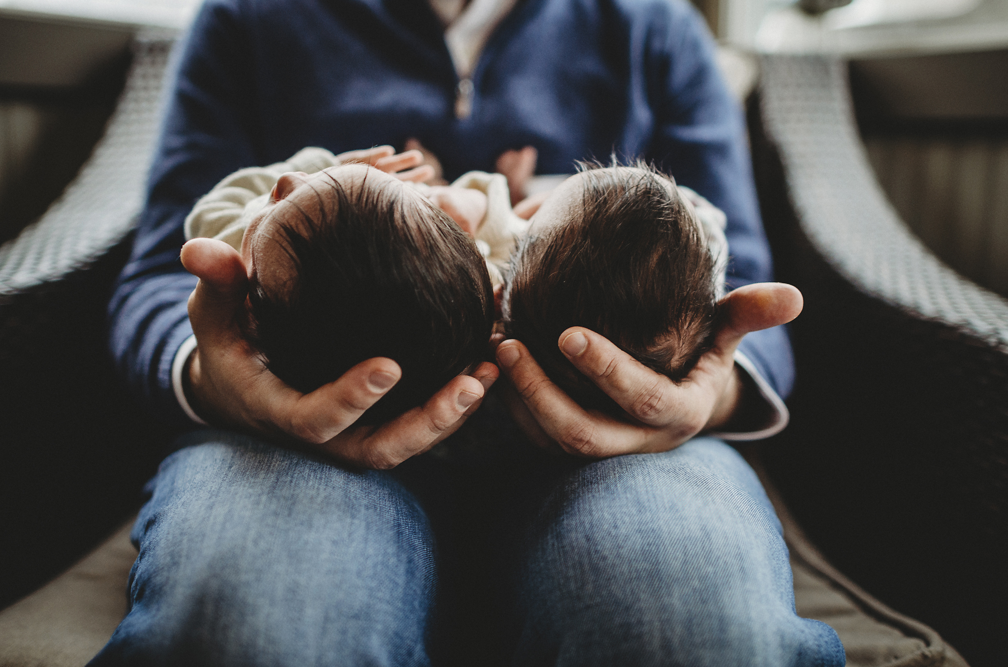 twin newborns in dad's hands