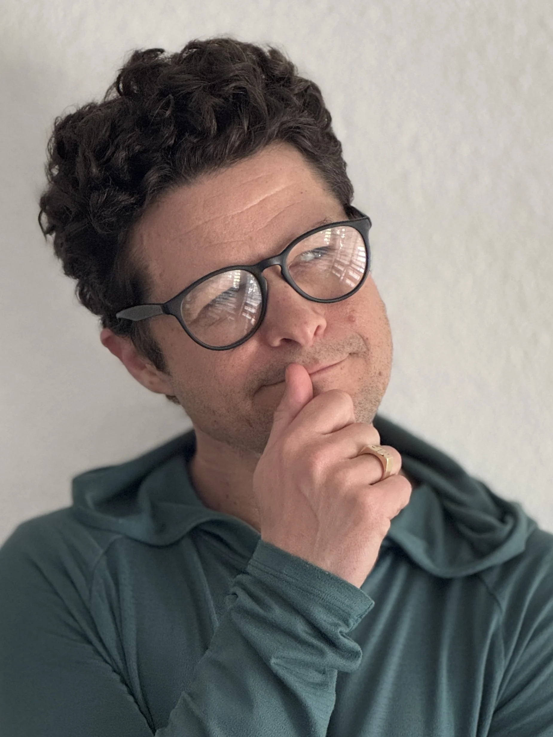 Headshot of Mike Paul - Hand rubbing chin, as he looks upward and to the side, as if contemplating something mischevious.
