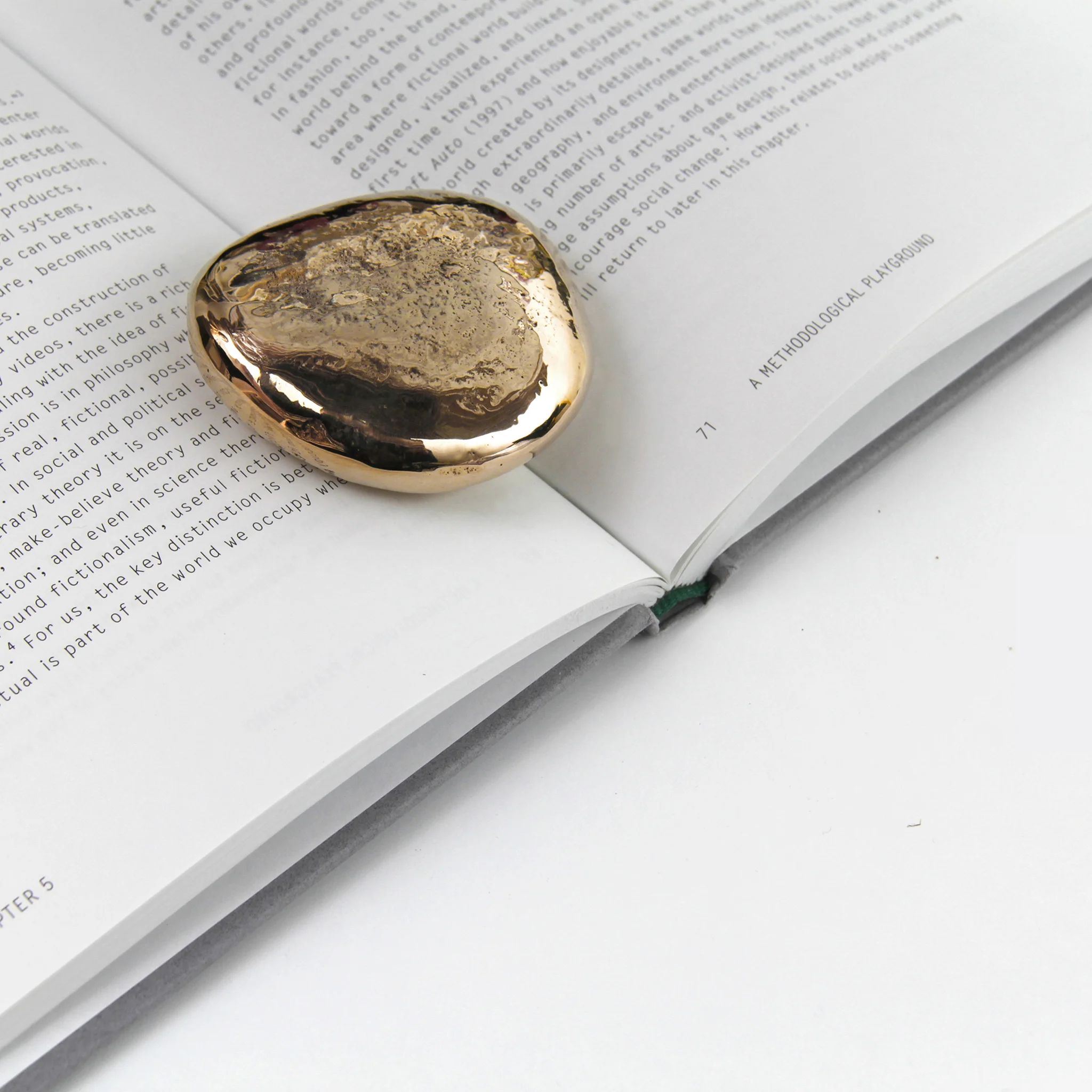 Pebble paperweight holding open a book