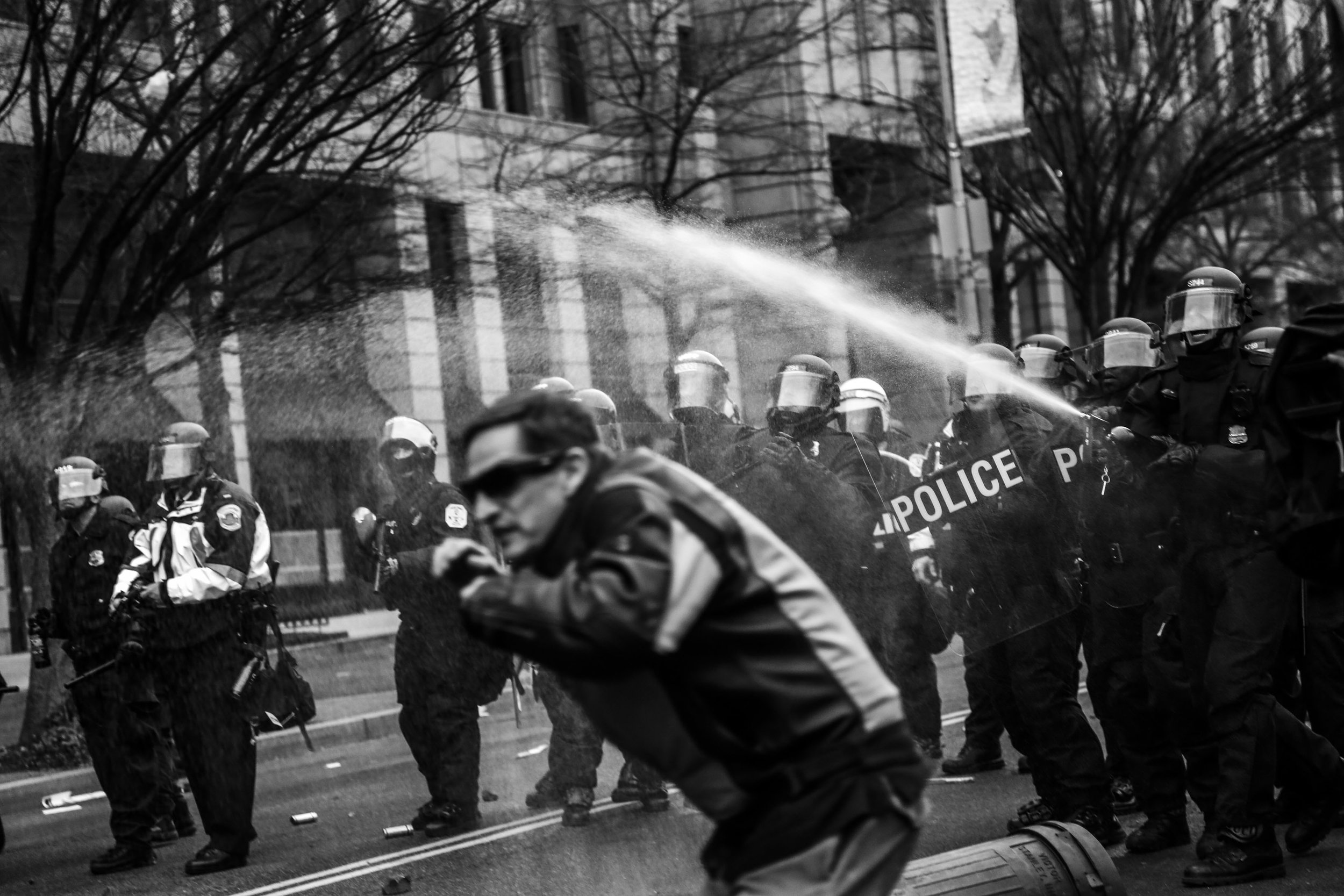   Police officers wearing riot gear spray protesters with pepper spray on K St. N.W.,&nbsp;hours after President Trump was sworn in as the 45th US President.  