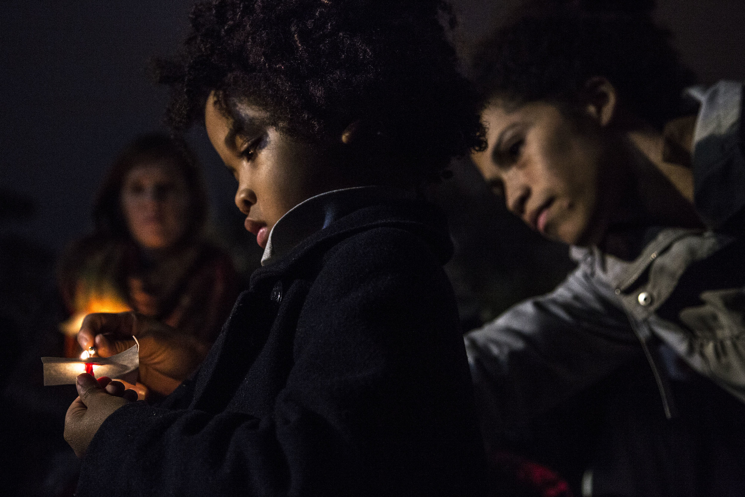   A mother lights the candle of her son during a candlelight vigil outside the White House, the evening after the 2016 presidential election.  