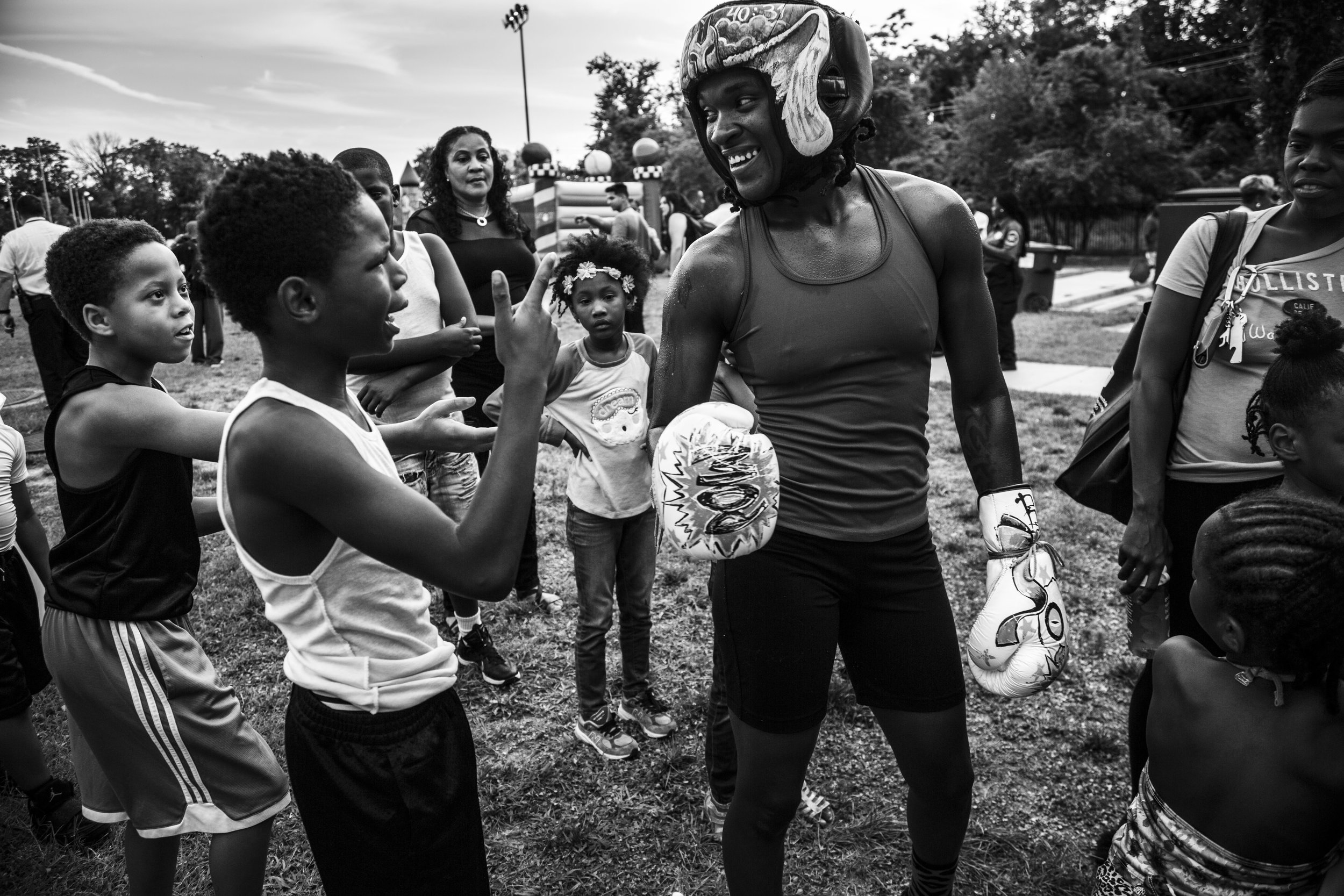   Tiara talks with young HeadBangers teammates during the Metropolitan Police Dept.’s National Night Out, an event that promotes police-community bonding.  