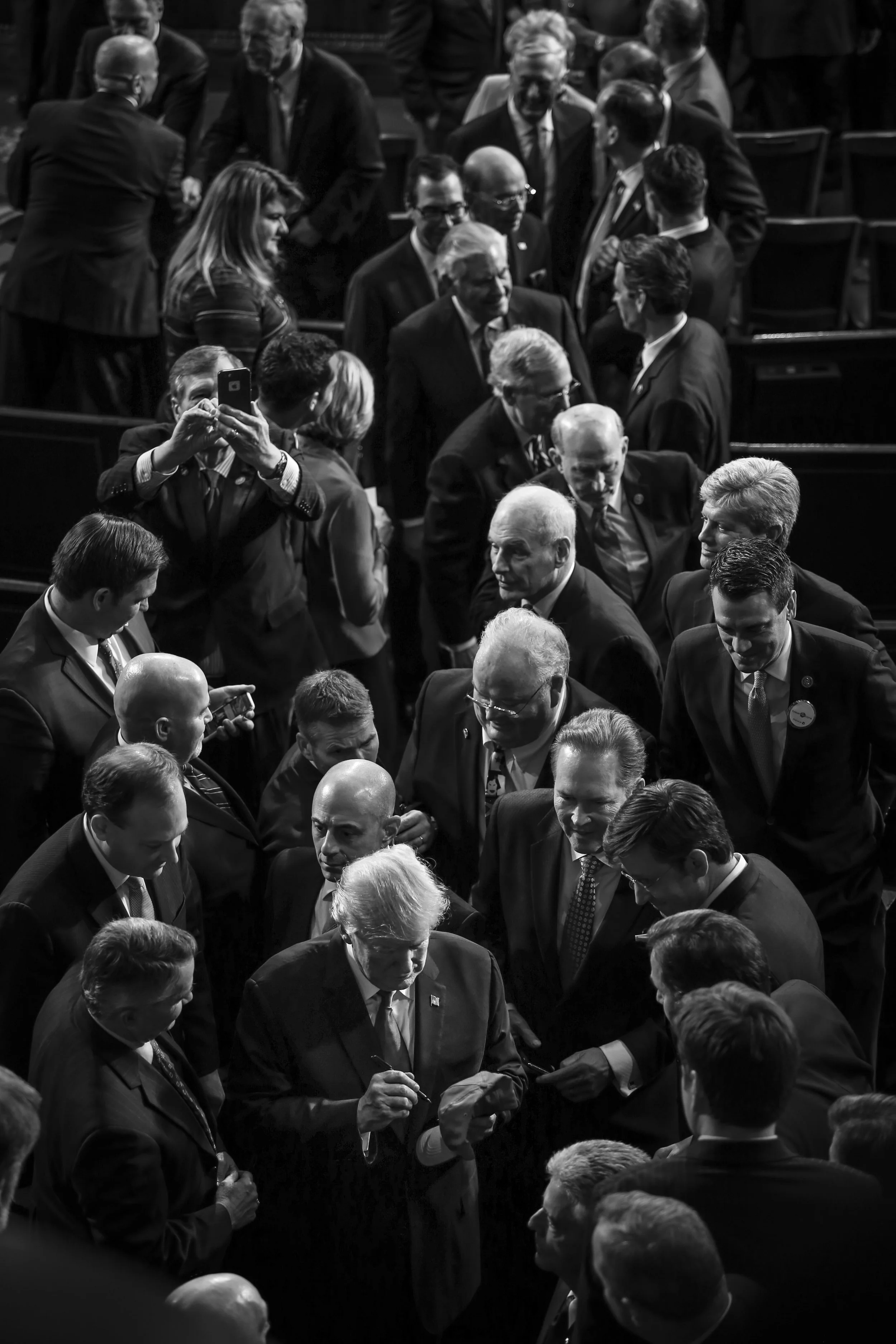 President Donald Trump signs a cap after delivering his first State of the Union address.
