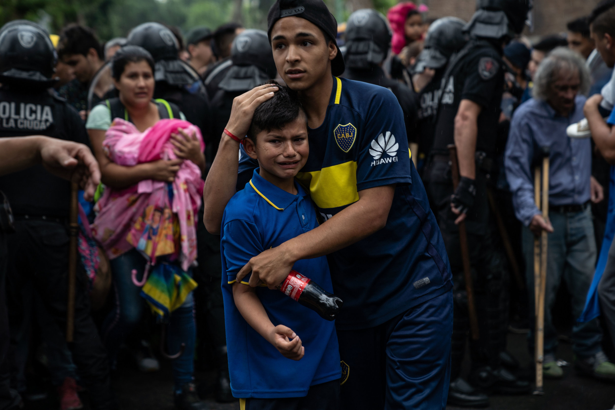   A young boy cries as crowds push to enter a Boca Juniors open training session prior to the Copa Libertadores final in Buenos Aires, Argentina in November, 2018.  