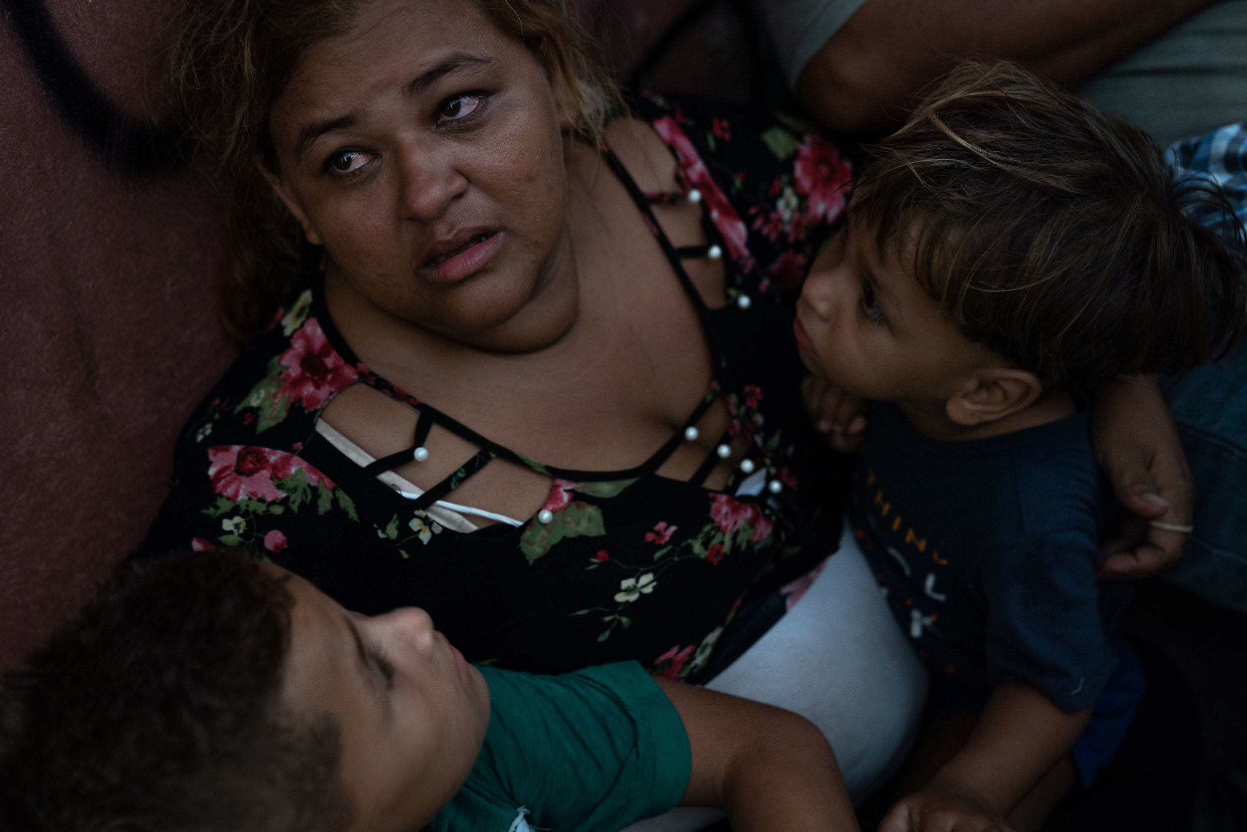   A Honduran migrant and her sons sit on a sidewalk, where they are sleeping due to shelters being over capacity in Tapachula, Mexico in June, 2019.  