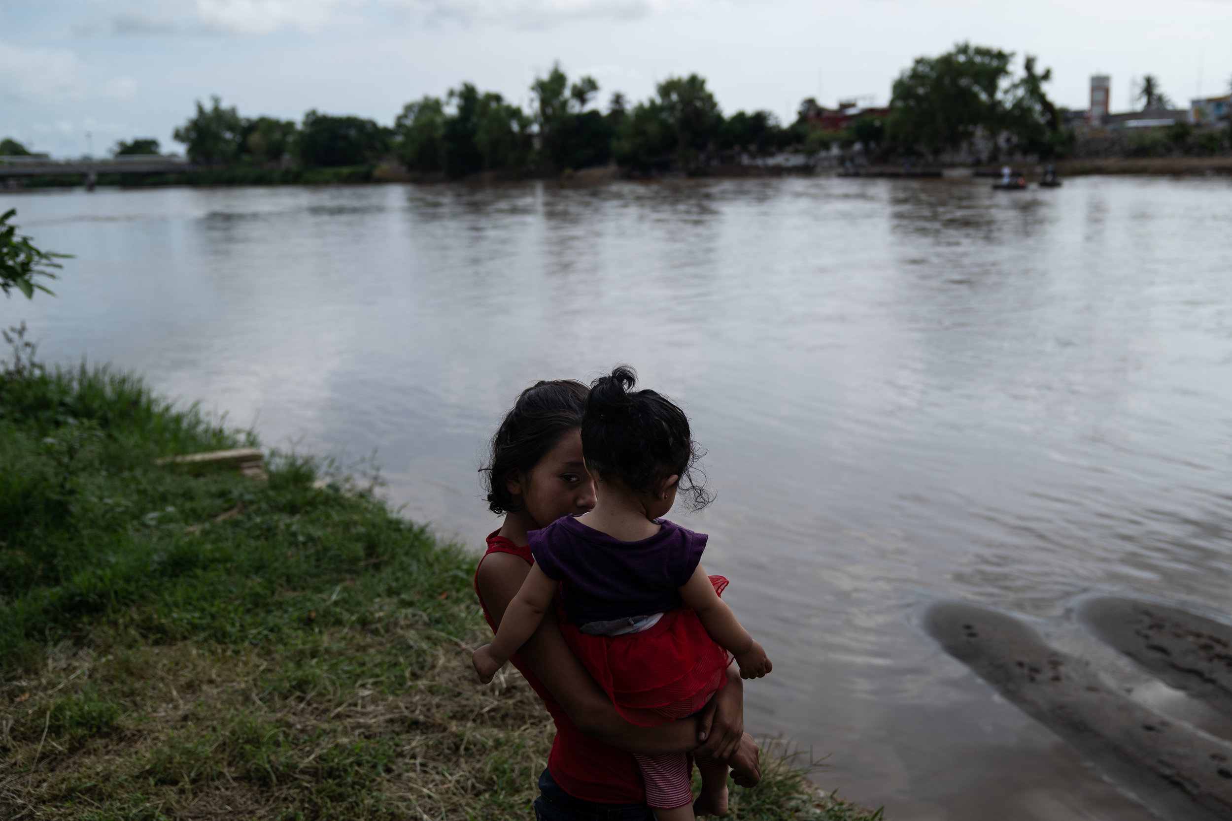   A woman and child stand next to the Suchiate river in Tecún Umán, Guatemala, 2018.   