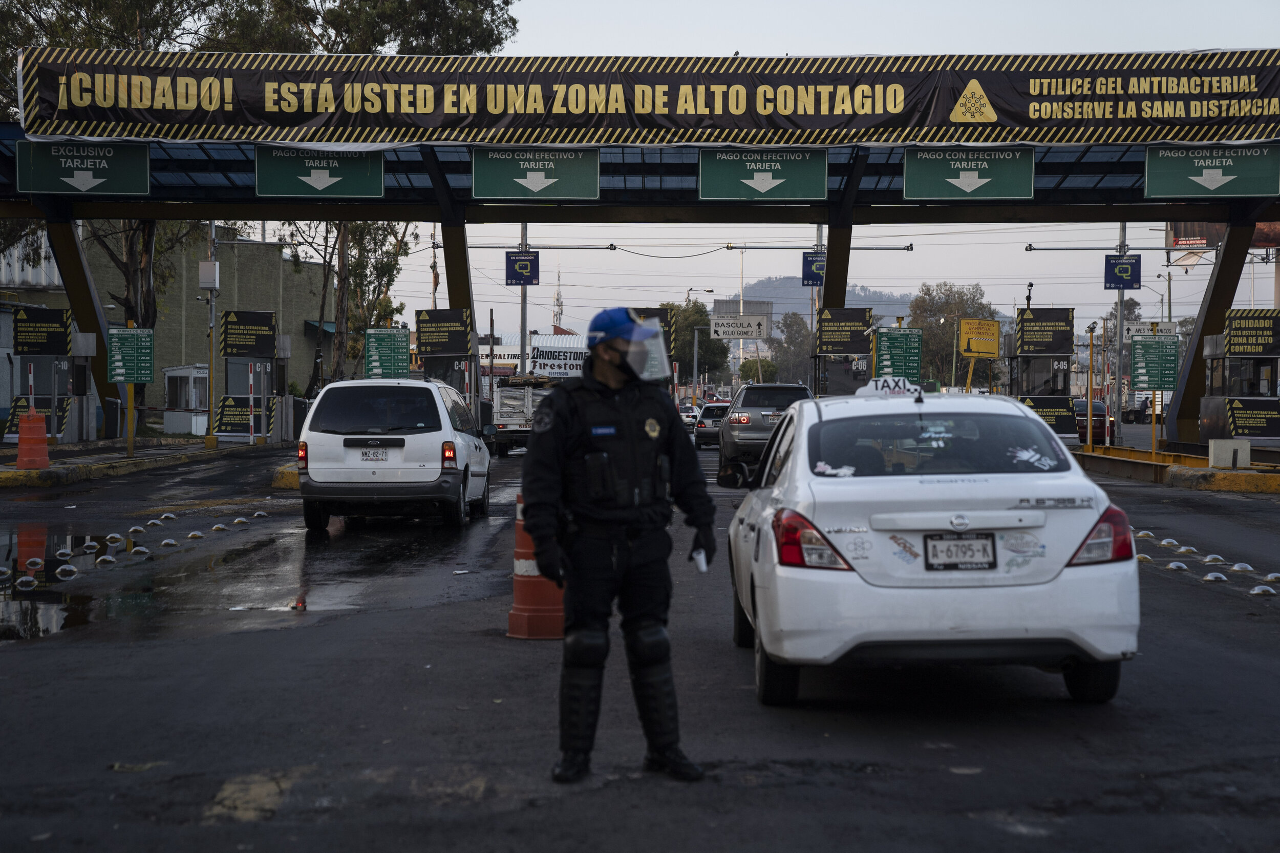   A police officer waits to measure the body temperature of people entering the Central de Abasto market, an important concentration of COVID-19 transmissions.   