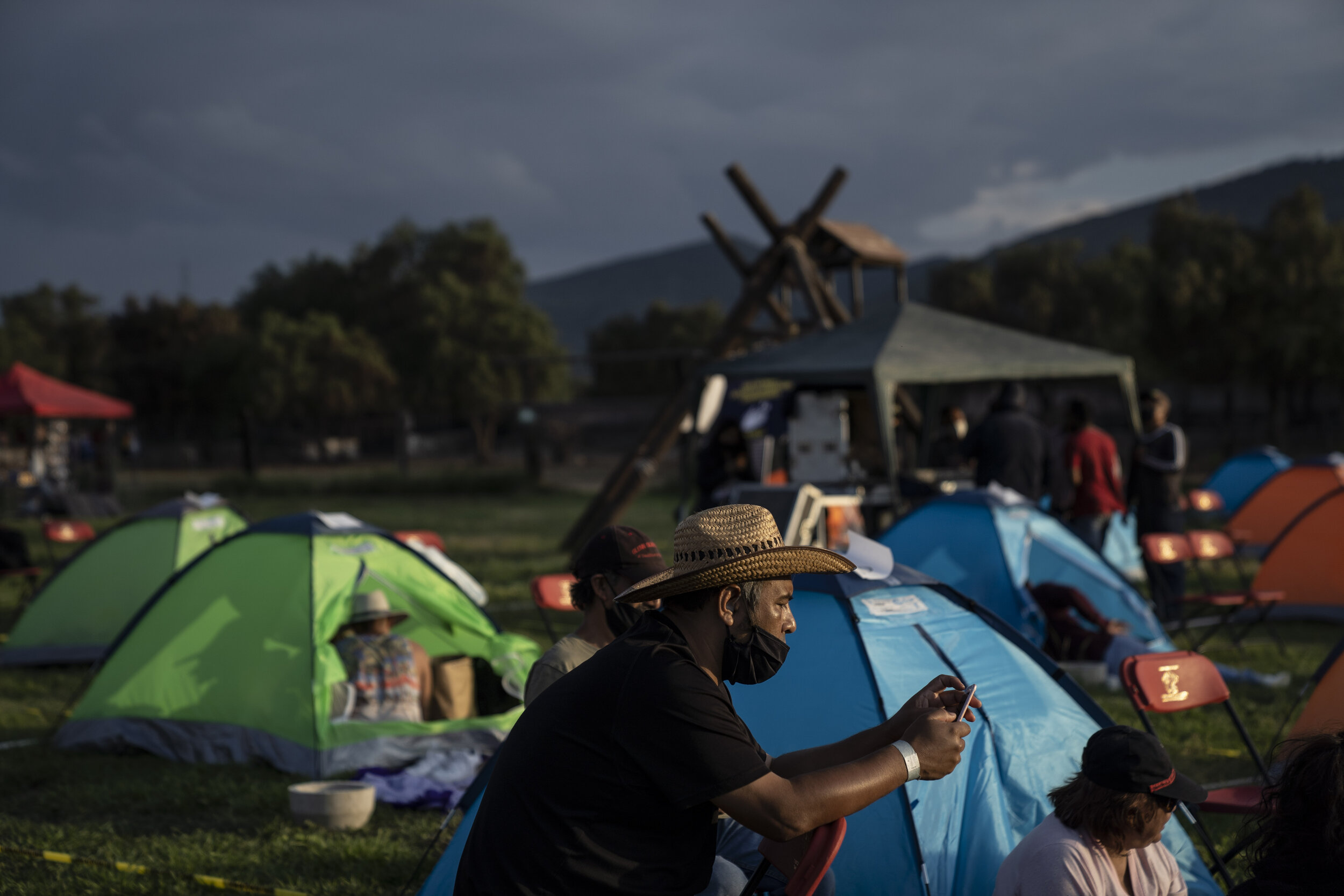   An attendee looks at his phone during the annual Noches Magicas de Teotihuacan event, which has reduced its capacity to 10%.  