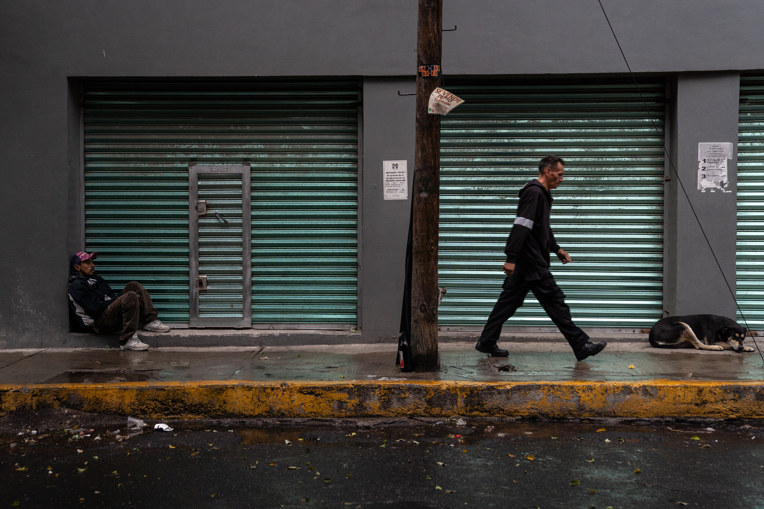   Juan sits on a sidewalk in the Buenavista neighborhood.   