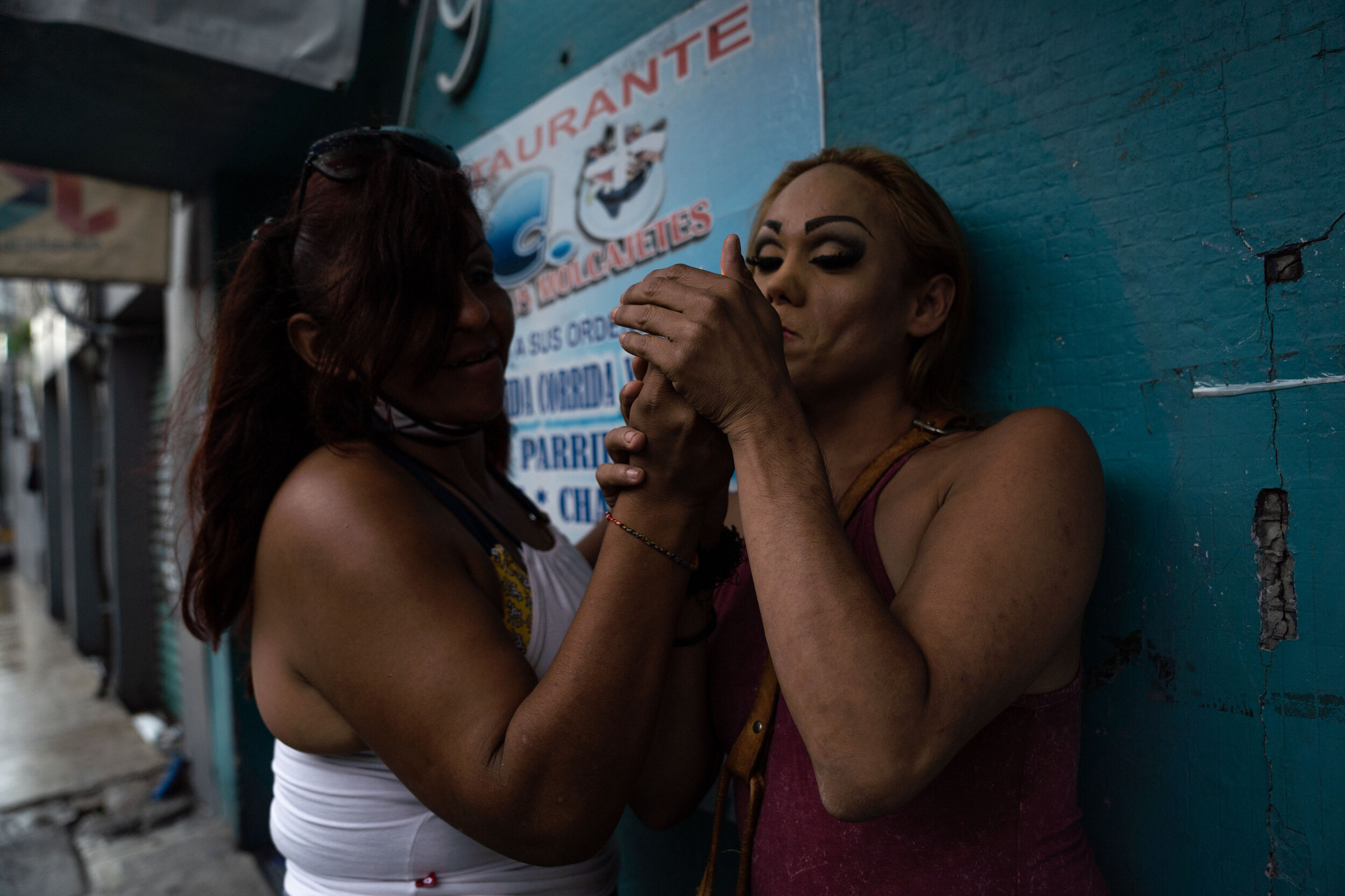   Nicky lights a cigarette while waiting for clients in the Buenavista neighborhood.   