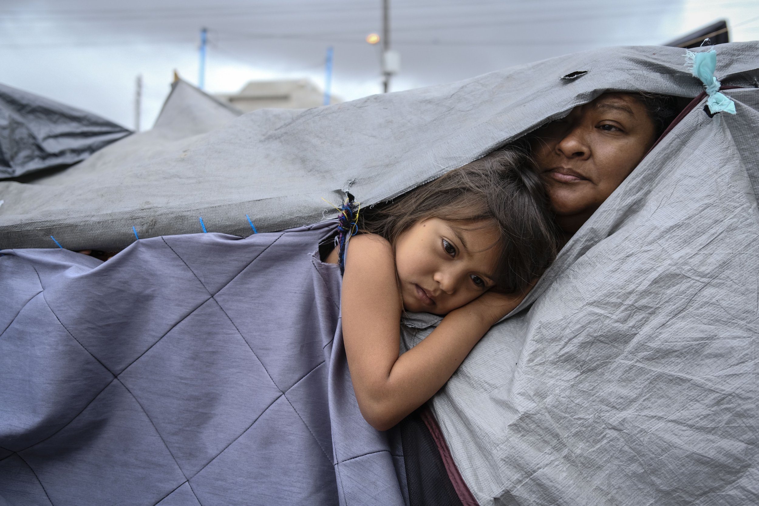   A Honduran woman and her niece look on at a makeshift migrant camp on April 22, 2021 in Tijuana, Mexico.  