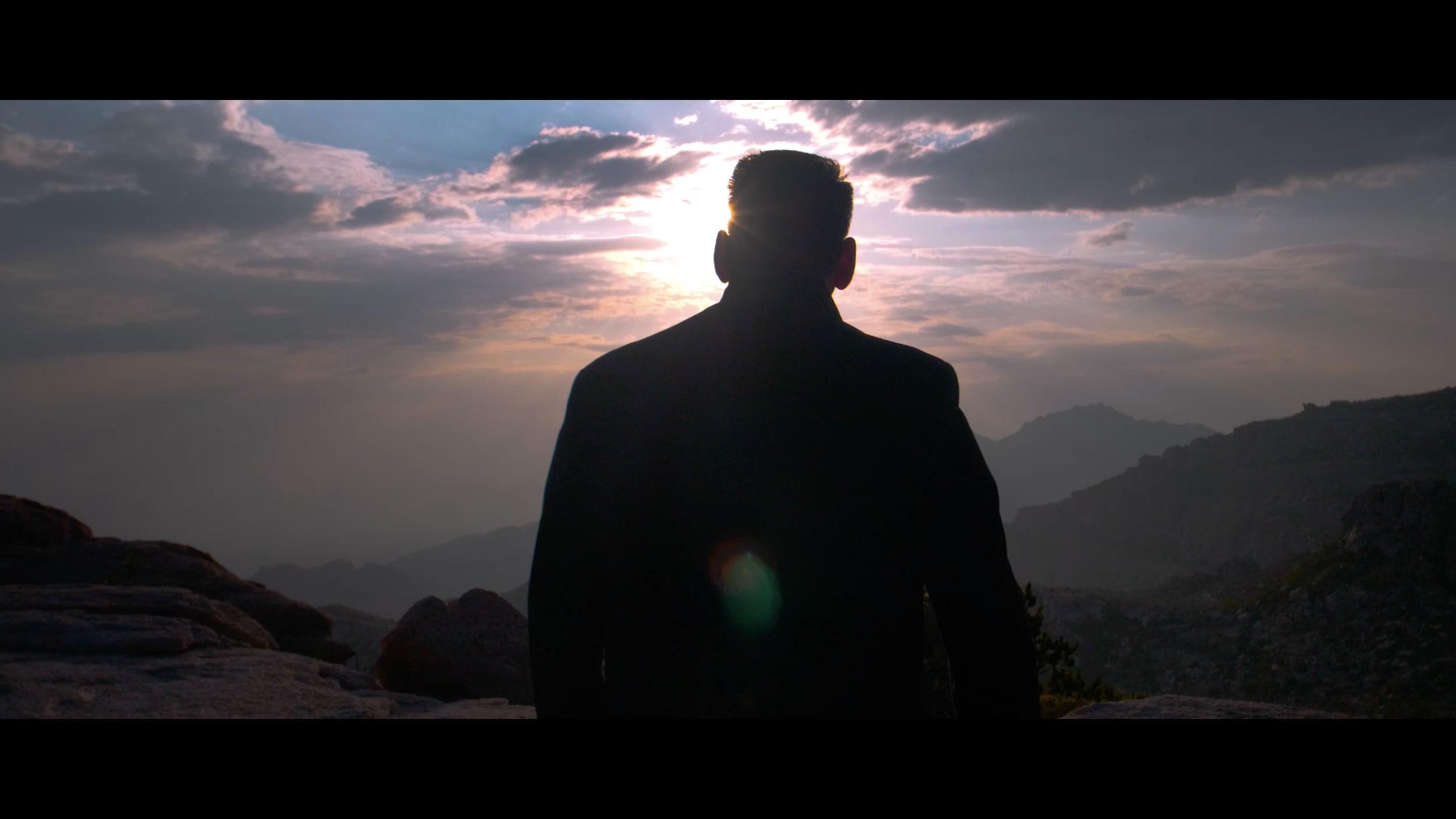 man silhouetted by sunset in jacket.png