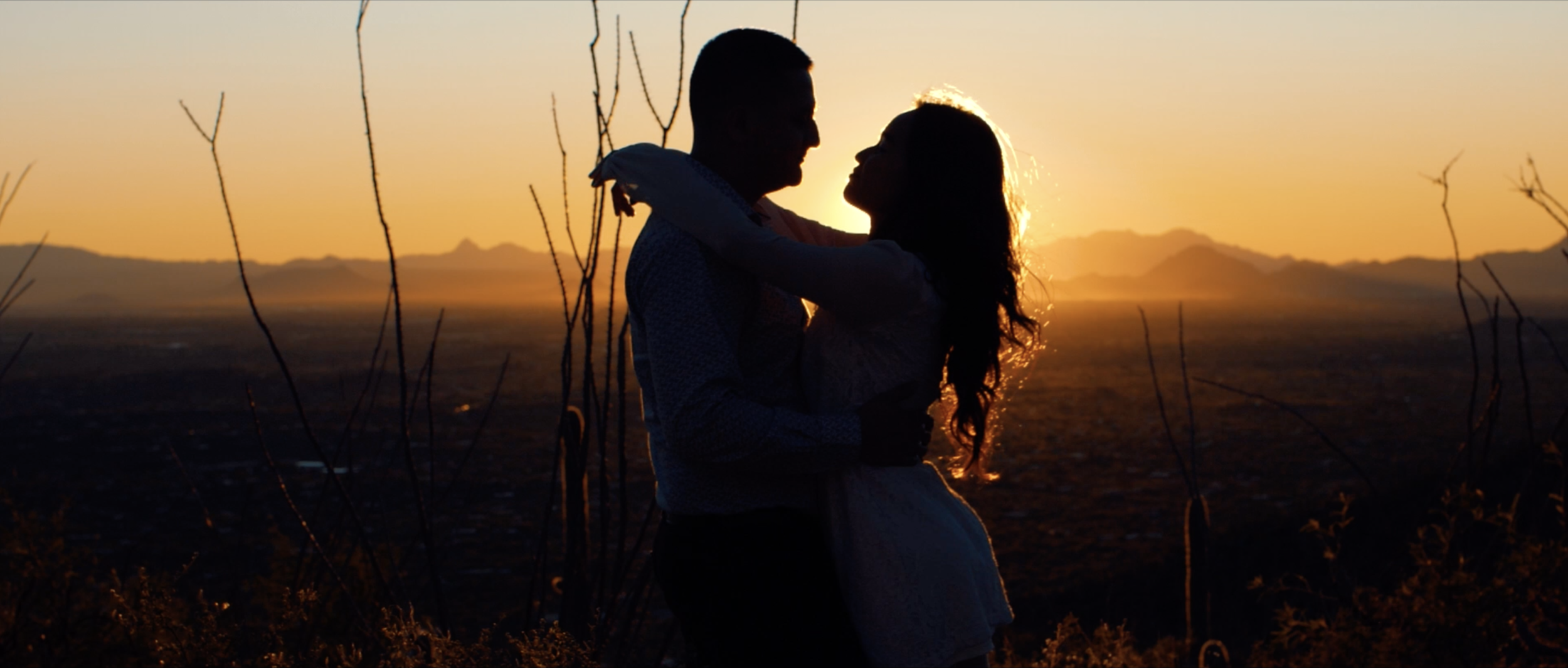 couple embracing silhouette sunset.png
