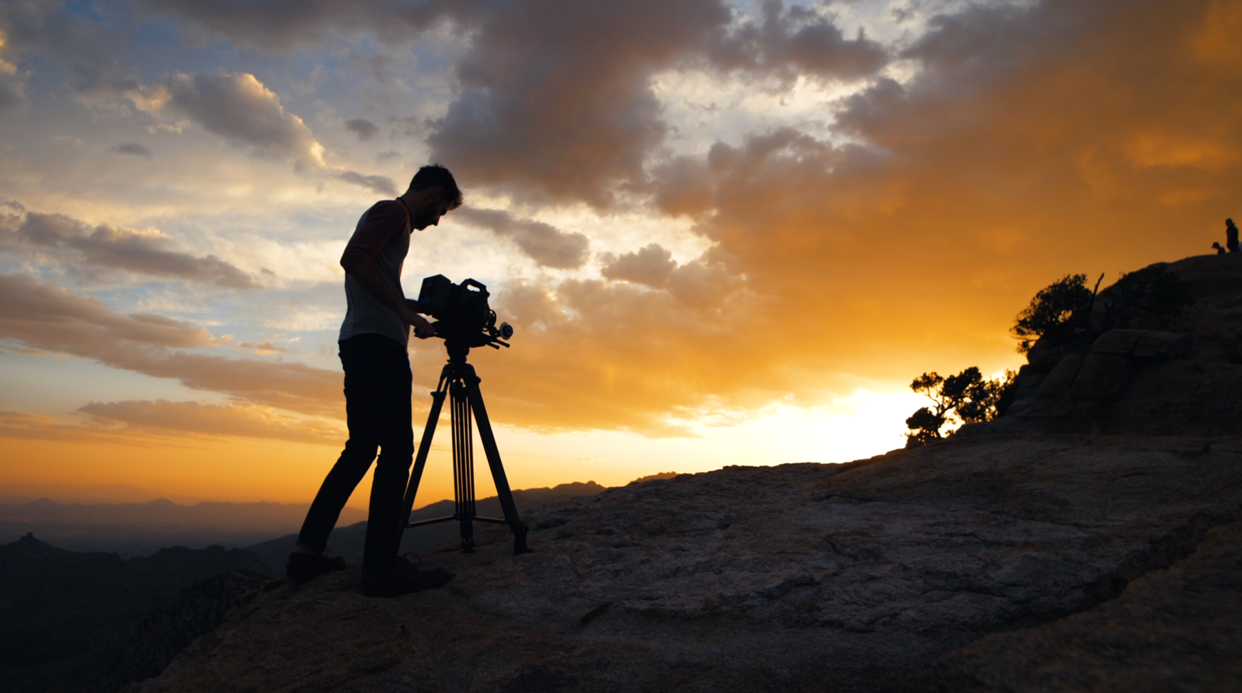 camera man silhouetted at sunset.png
