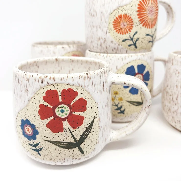 White and green flower mugs in speckled white