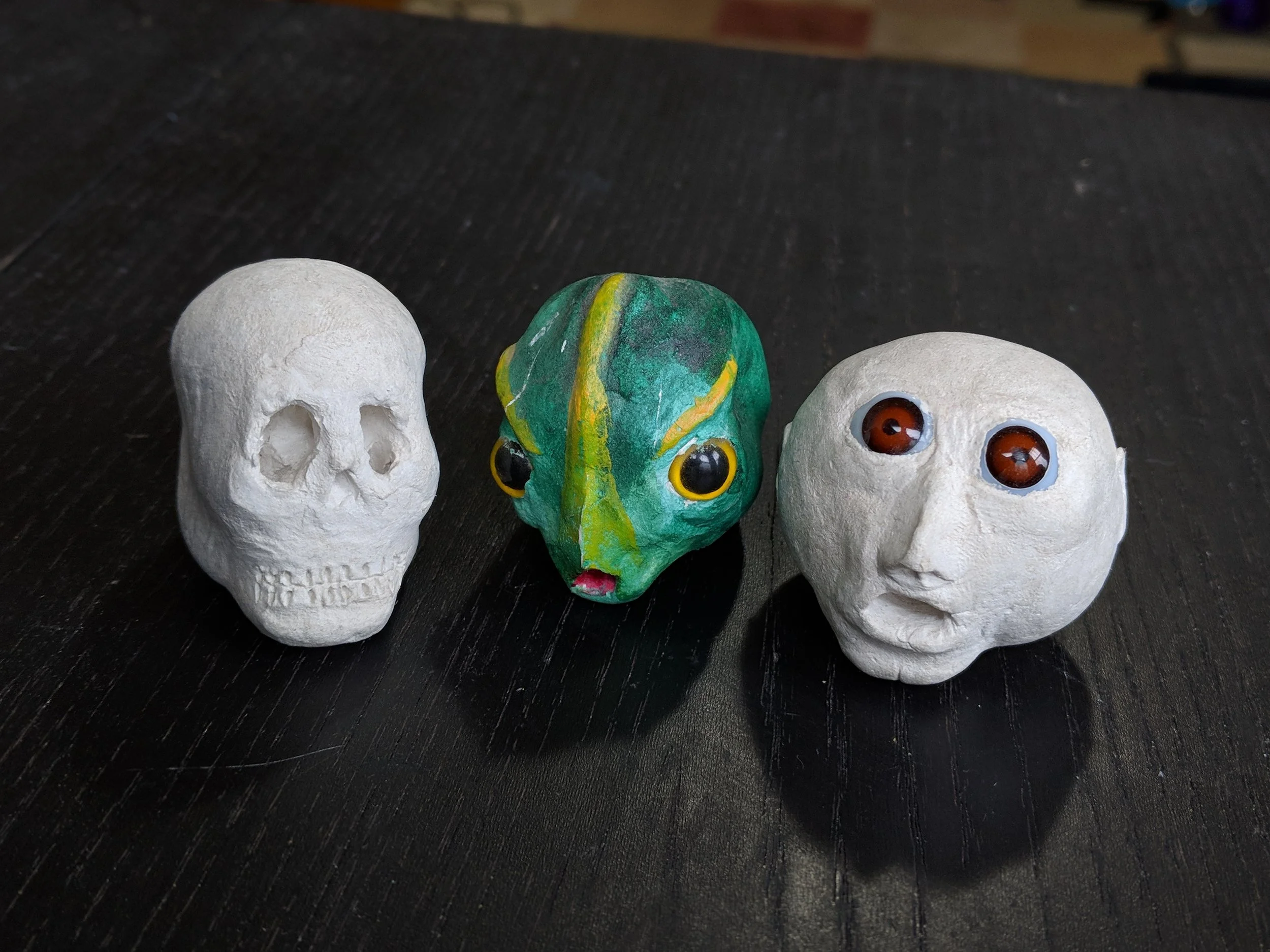 Three rod puppet heads used for a performance many years ago. Sadly the bodies were long ago lost to time and one of many moves. From left to right: death, a fish-human hybrid, and a very nervous angel.