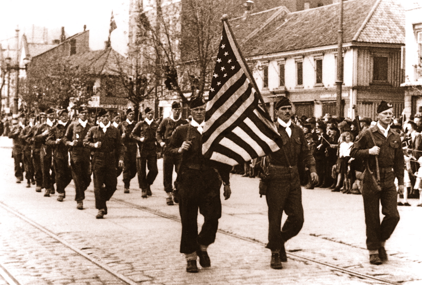 May, 1945: U.S. paratroopers march the Ericksons’ 48-star flag down a street in Trondheim, Norway following the city’s liberation from German occupation.