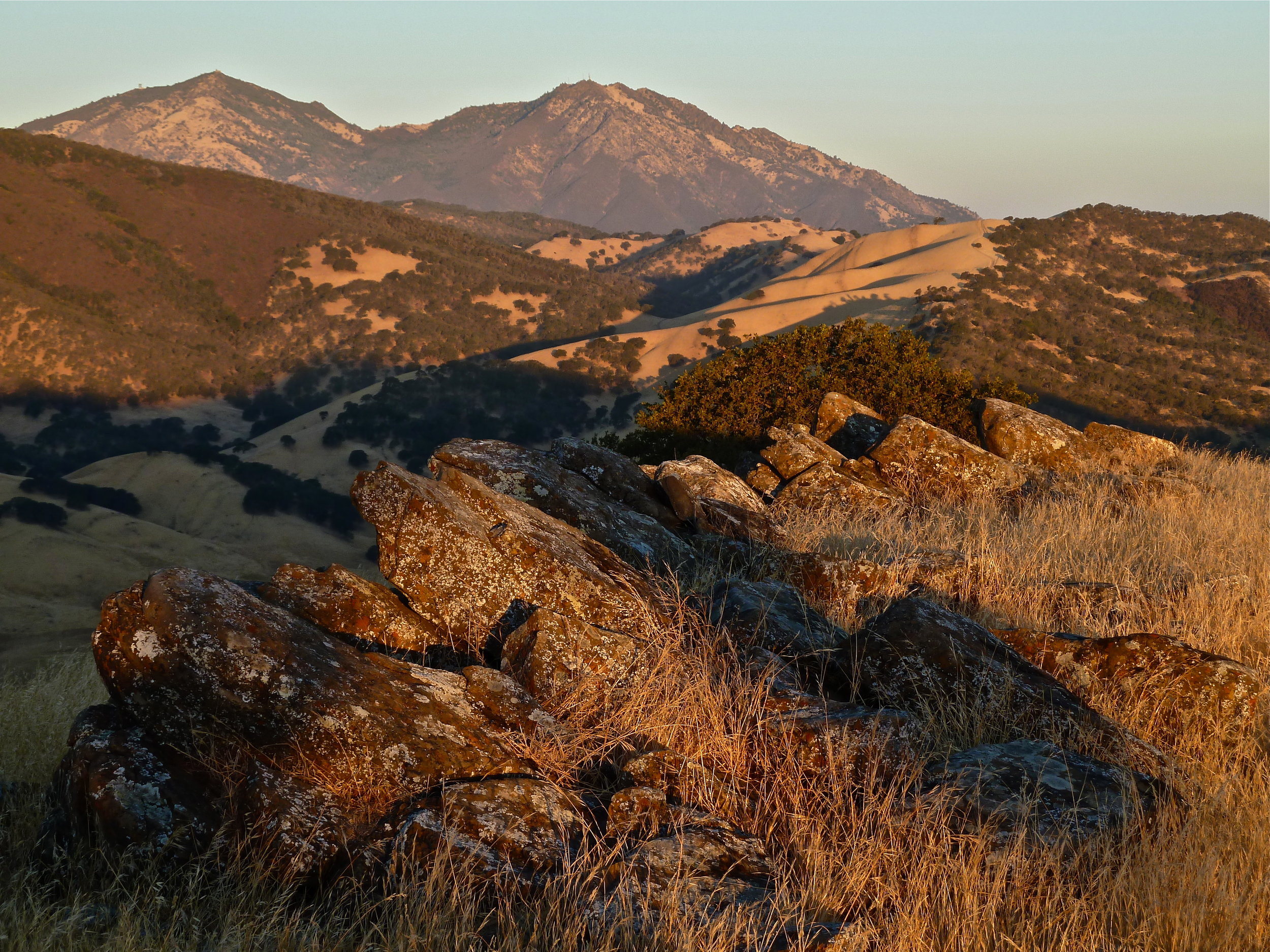 A warm summer sunrise strikes Round Valley's Castle Ridge. Eight miles northwest rises Mt. Diablo.