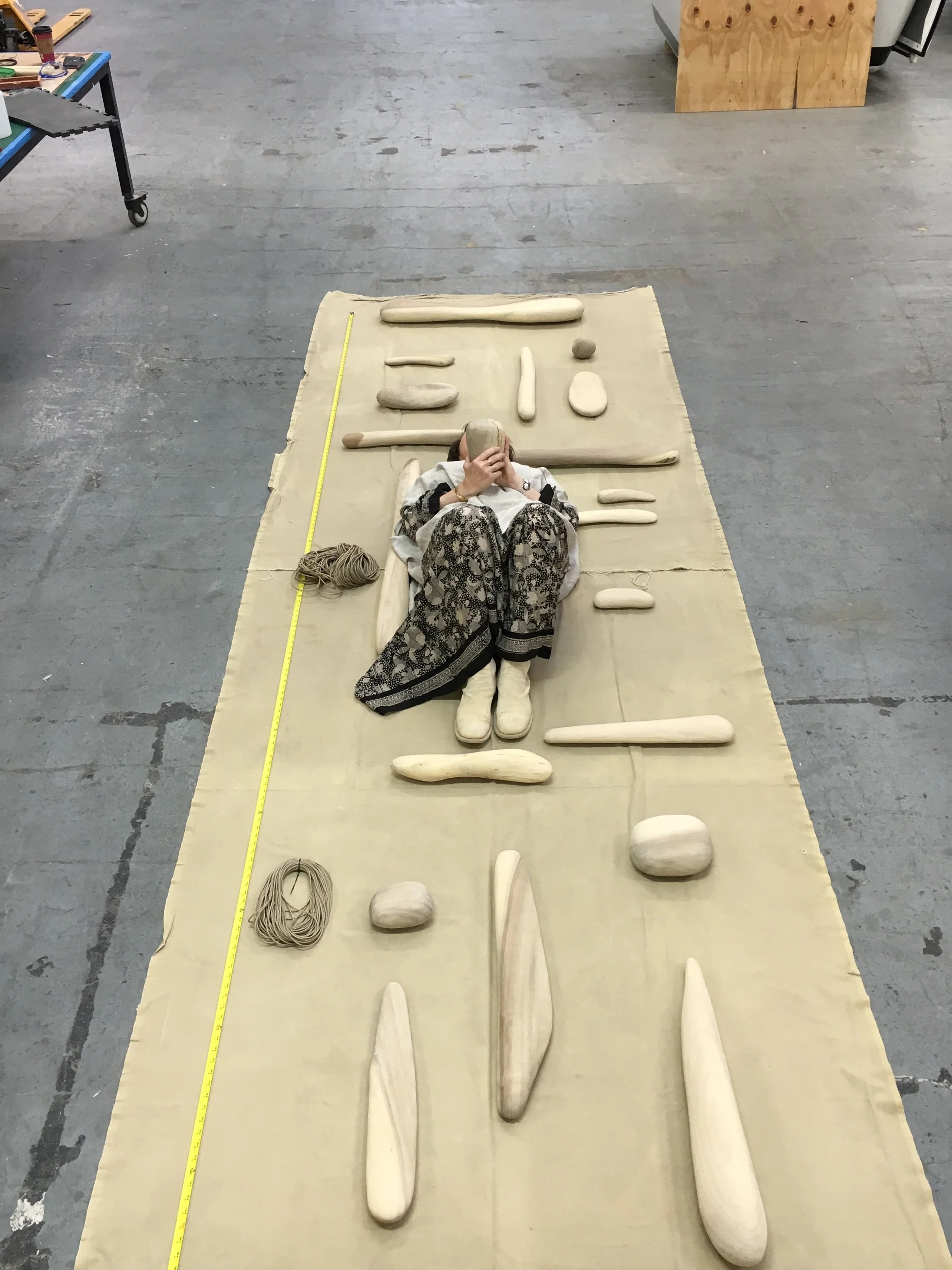 Ruth Kneass laying with the meticulously sculpted pieces of her Bay Tower mobile. © Ruth Kneass