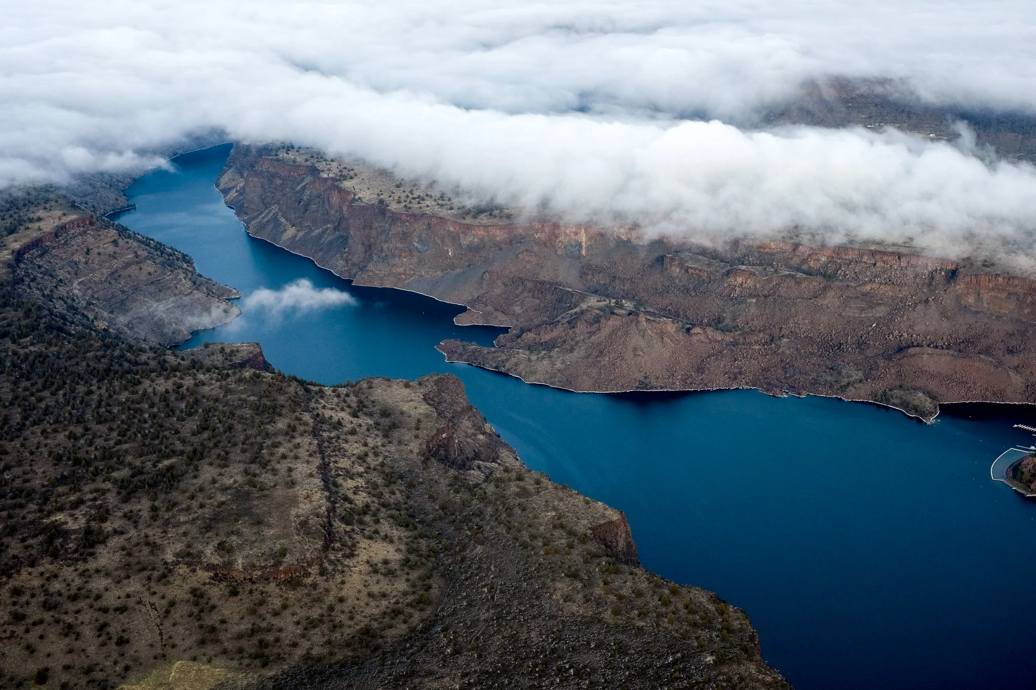 The shimmering blue surface of Lake Billy Chinook revealed by a hole in the clouds.