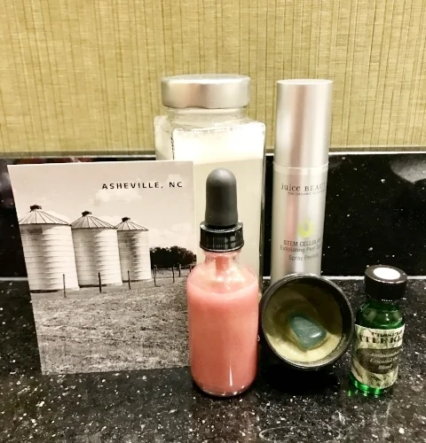 Some nontoxic travel beauty essentials while in Asheville, NC (clockwise from front: D.I.D. with Cazoshay Monokeros Love Rose Quartz Serum , D.I.D. with Cazoshay Aventurine Matcha Love Balm , Needful Things Battle Better , Juice Beauty Stem Cellular Exfoliating Peel Spray, Nontoxic Face Wash+Makeup Remover