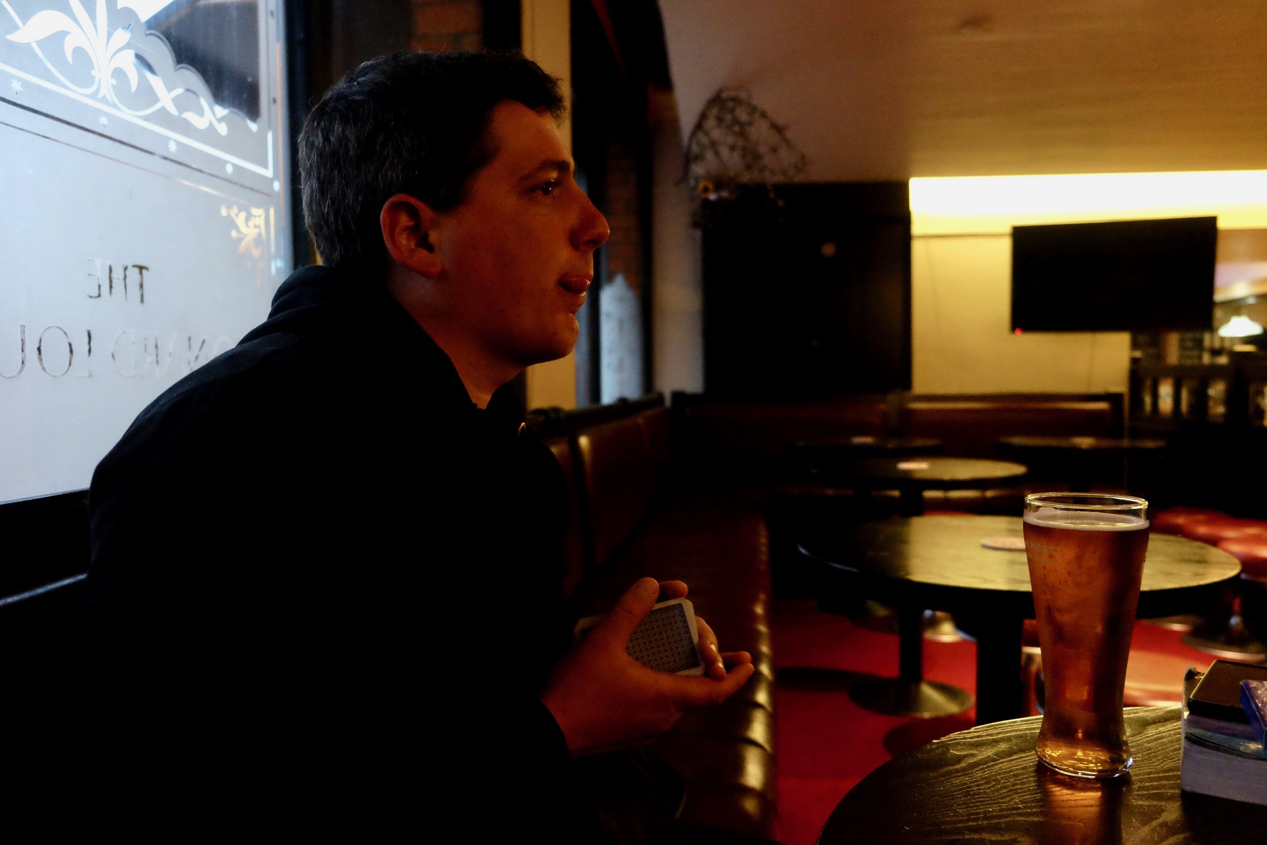 Neil in his element: pint, playing cards, football on the TV, and someone to poke his tongue at.