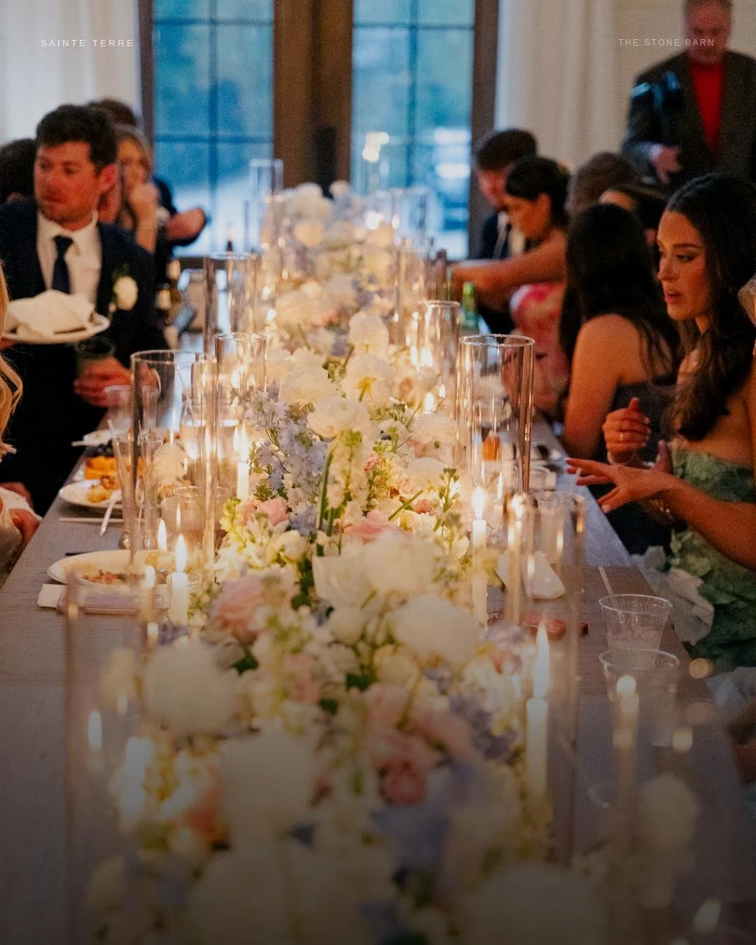 I want a house with a crowded table.
 
This is the image I keep coming back to from Caroline and Elliotte's wedding. Not the ceremony. Not the first dance. This.
 
A long table disappearing into candlelight. Flowers spilling over the edges. Friends l
